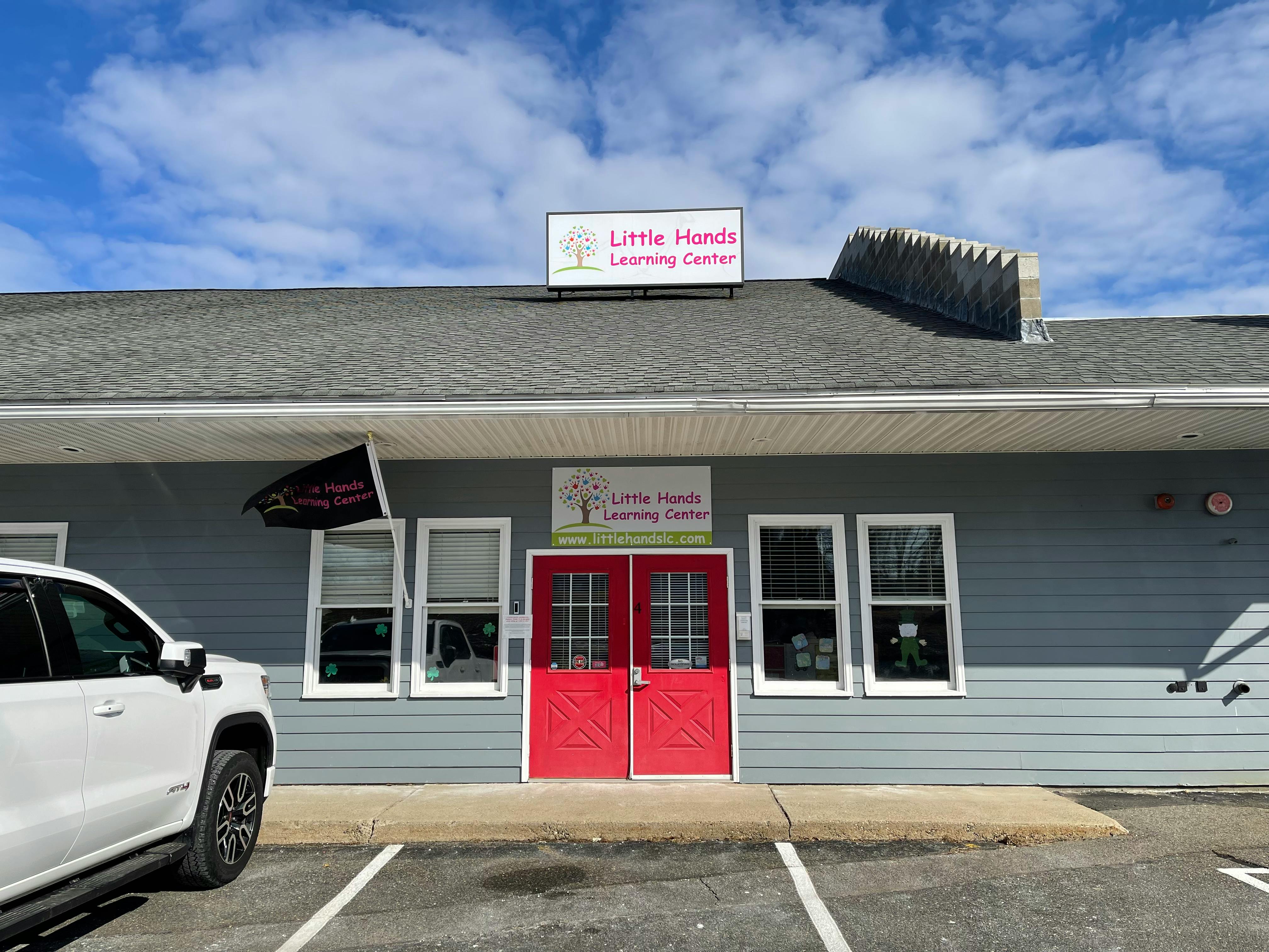 Building with red double doors and a sign that reads "Little Hands Learning Center"
