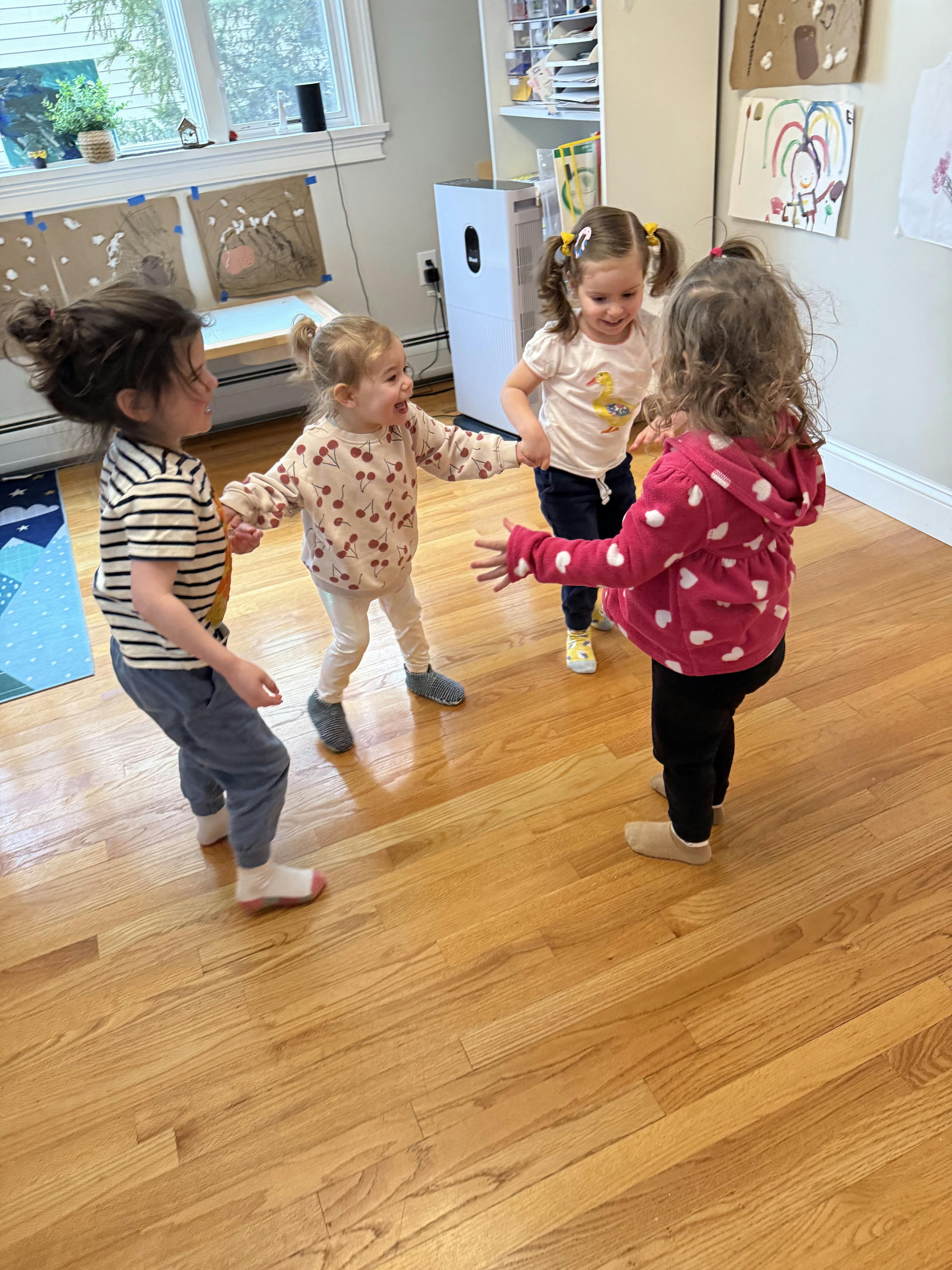 Four children holding hands in a circle
