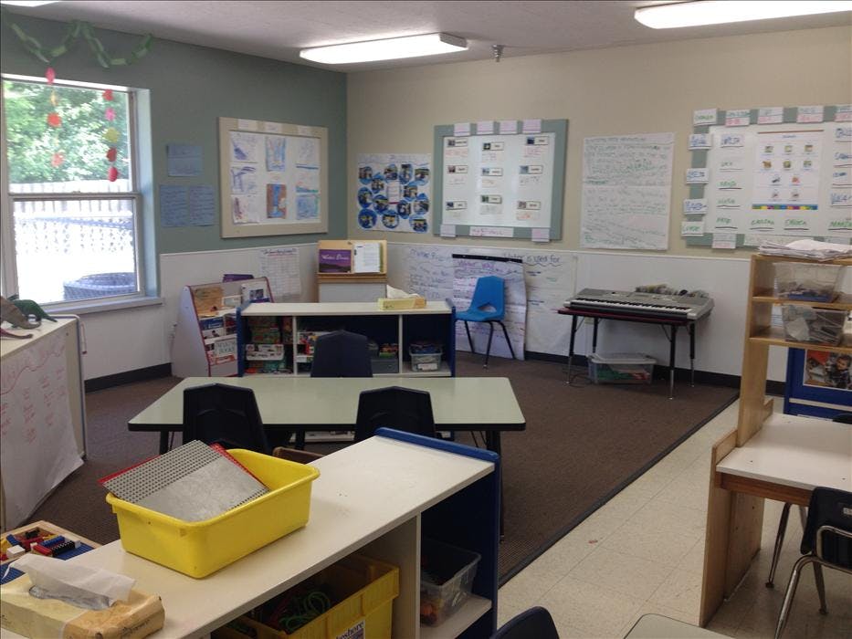 Empty classroom with tables, chairs, teaching materials, and a keyboard