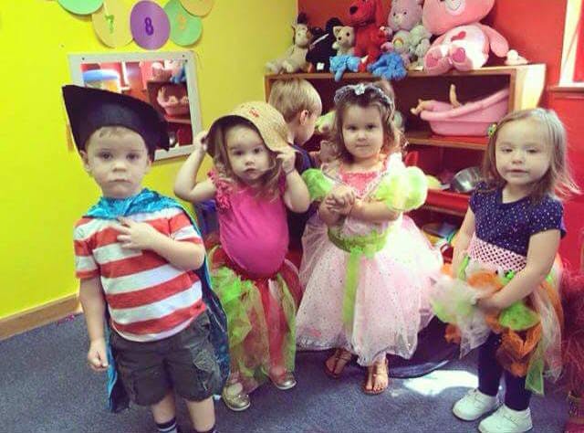 Children in costumes standing in a room
