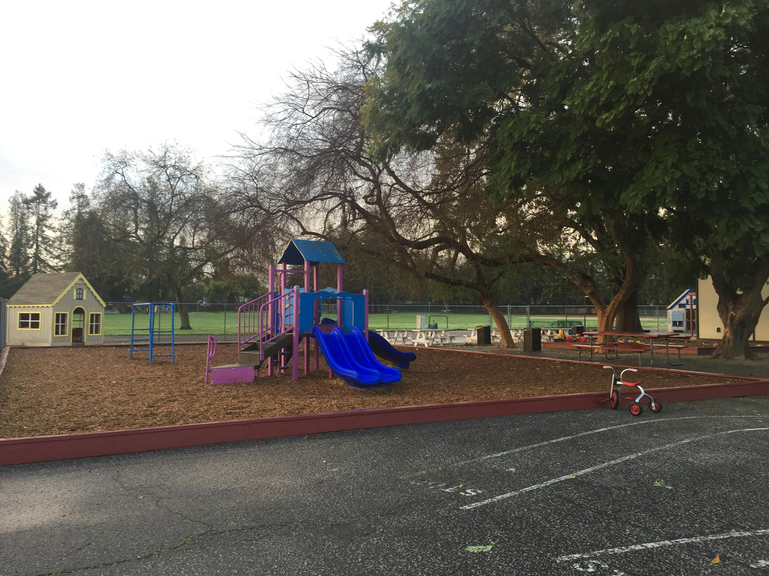 Playground with slides, swings, and a small playhouse