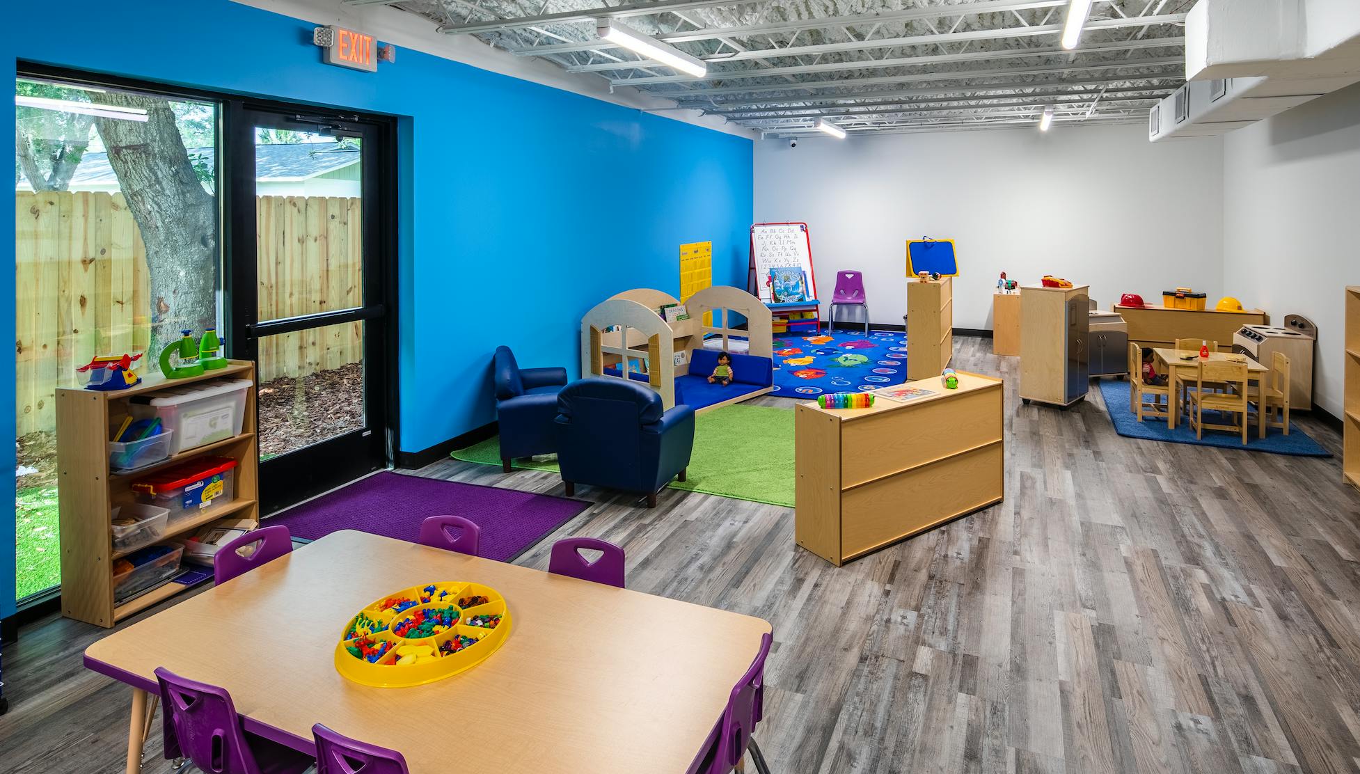 Children's classroom with small tables, chairs, and play areas