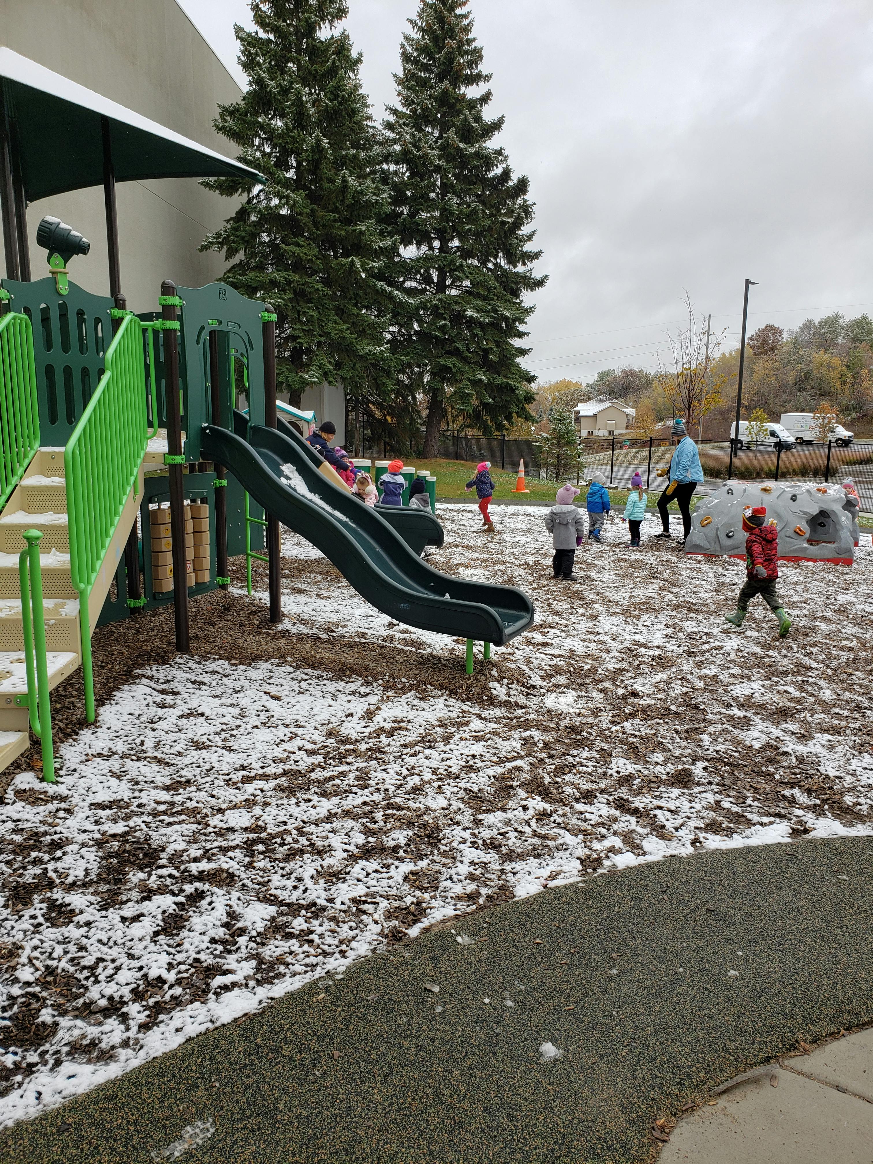 Children playing on a snow-dusted playground