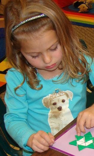 Child looking down at a craft project