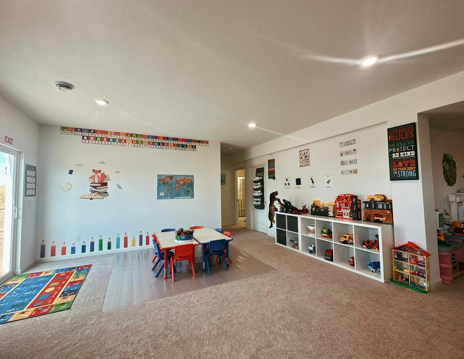 Children's play area with small tables, chairs, and toy shelves