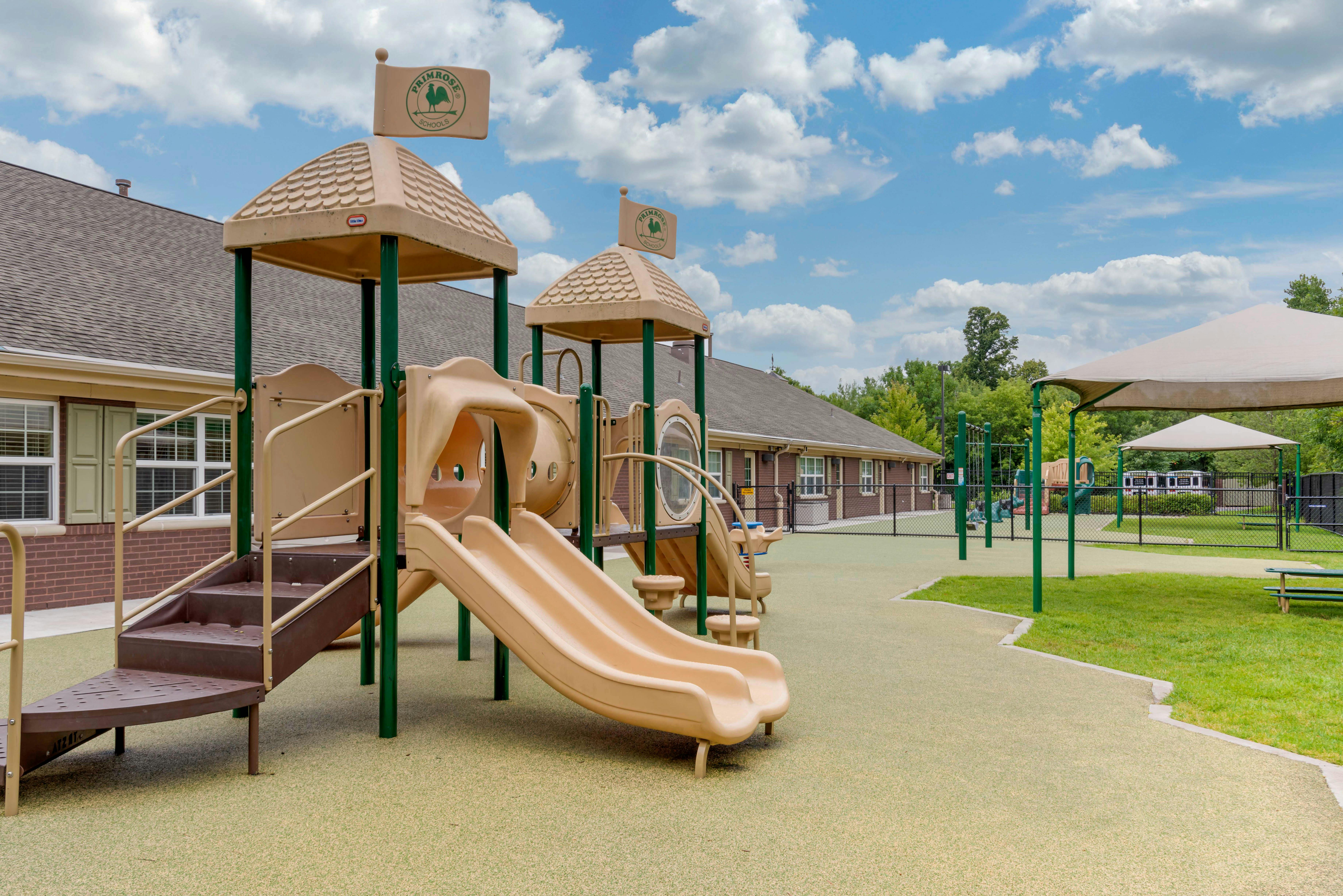 A beige playground structure with slides and a climbing area