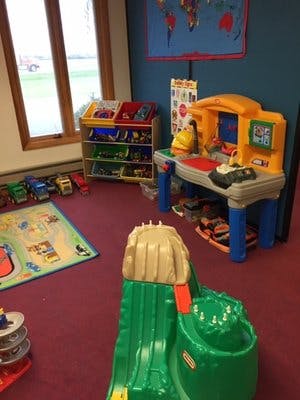 Playroom with toy storage, workbench, and play mat
