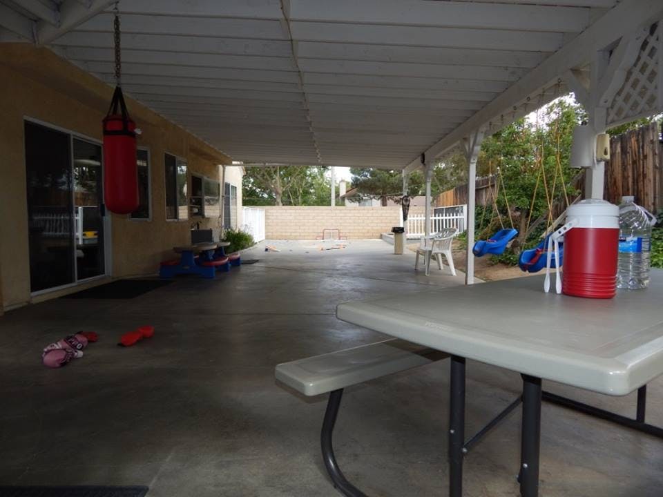 Covered patio with a picnic table, punching bag, and children's toys