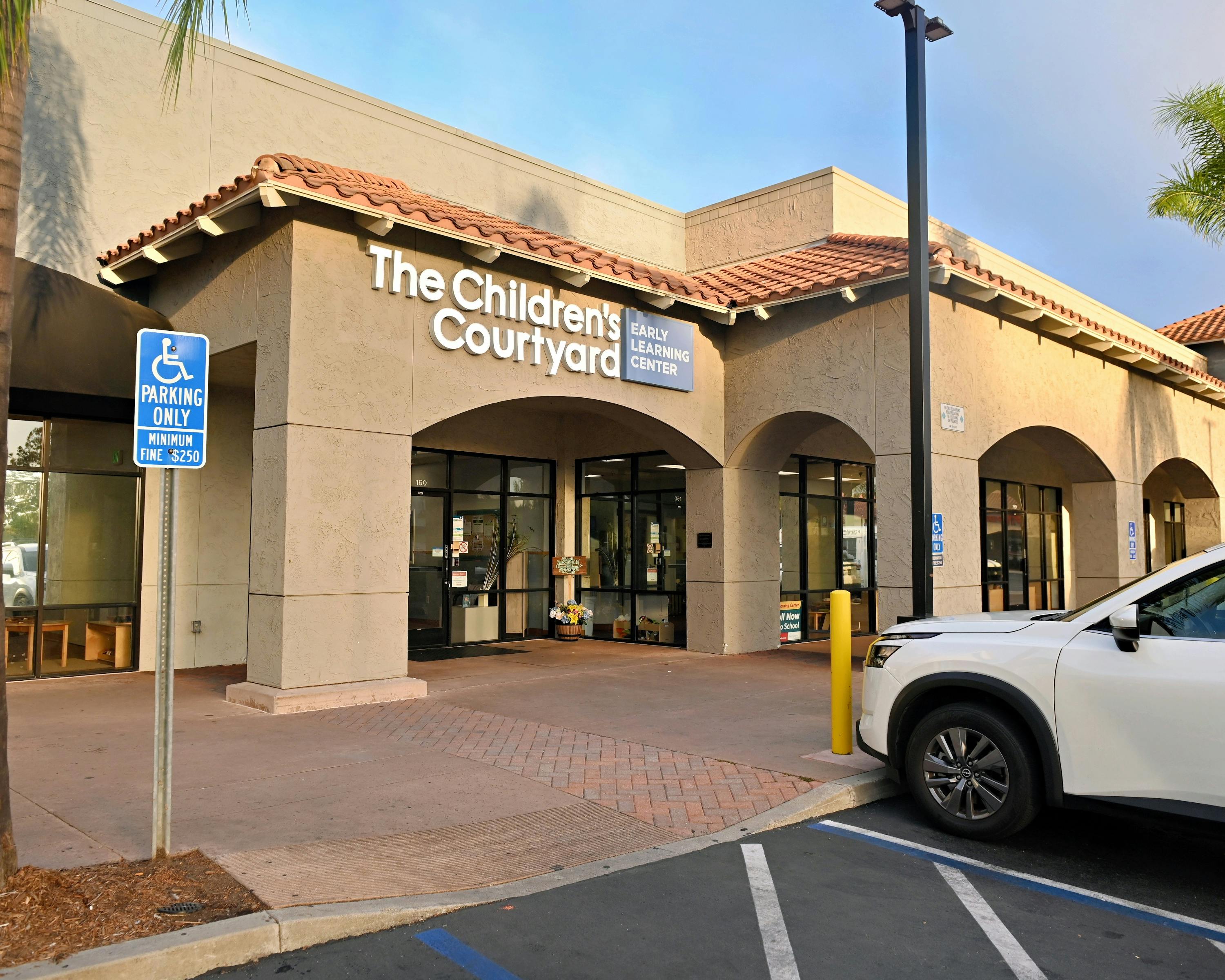 Entrance to a building with "The Children's Courtyard Early Learning Center" sign