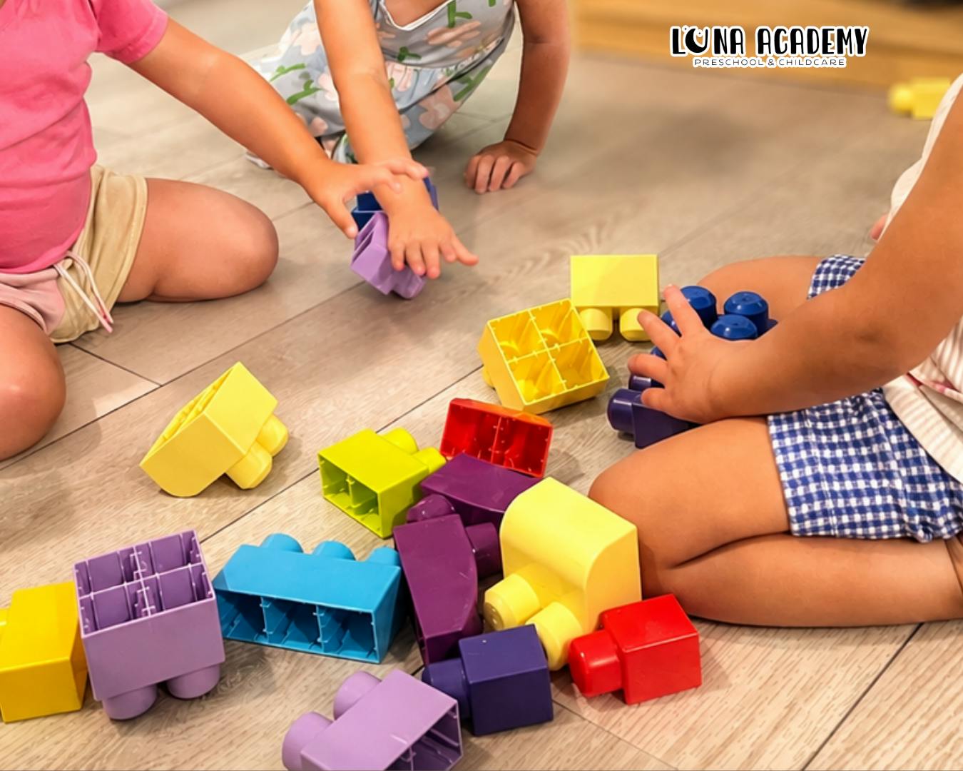Children playing with colorful plastic building blocks on the floor