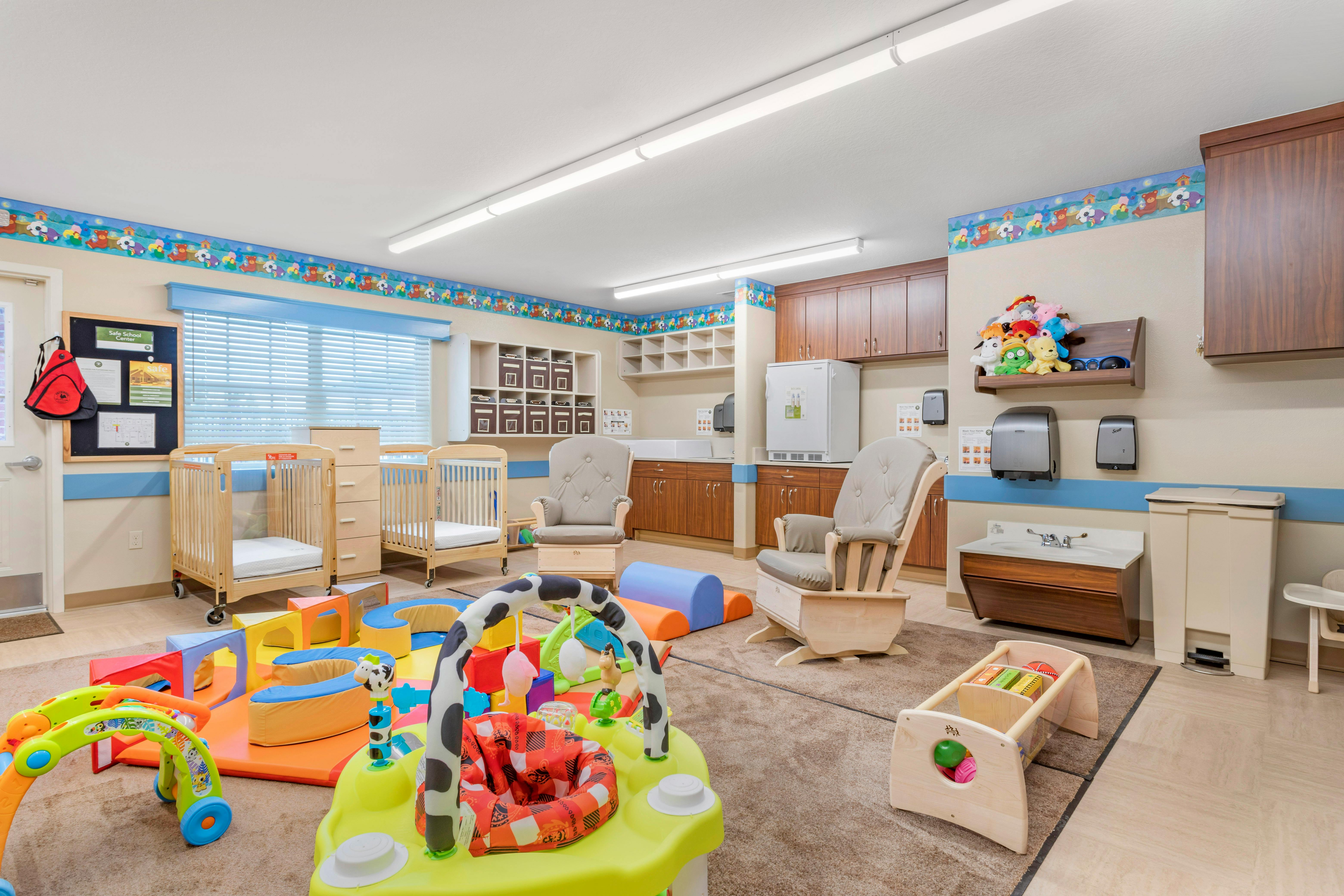 Baby room with play mats, cribs, child chairs, and changing station