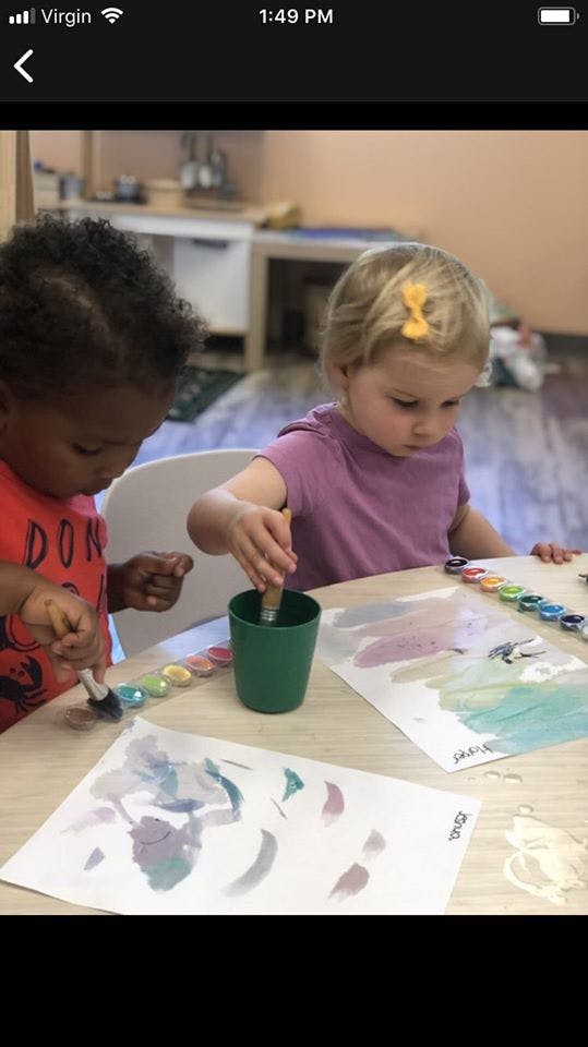 Two children painting at a table