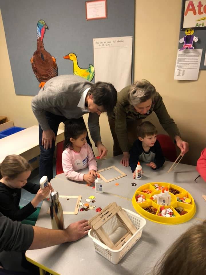 Adults and children doing crafts at a table