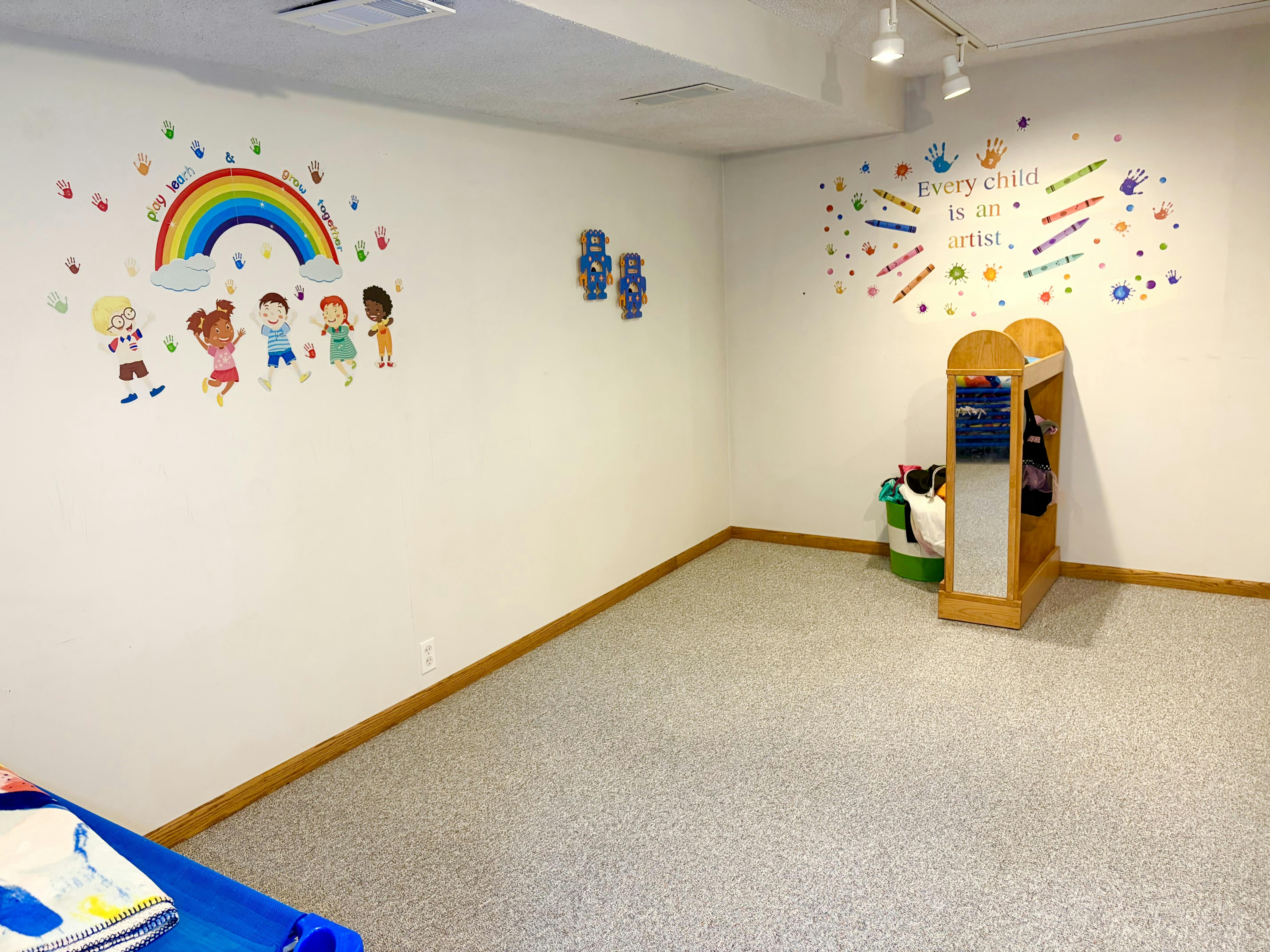 Playroom with wall decals of children and the text Every child is an artist