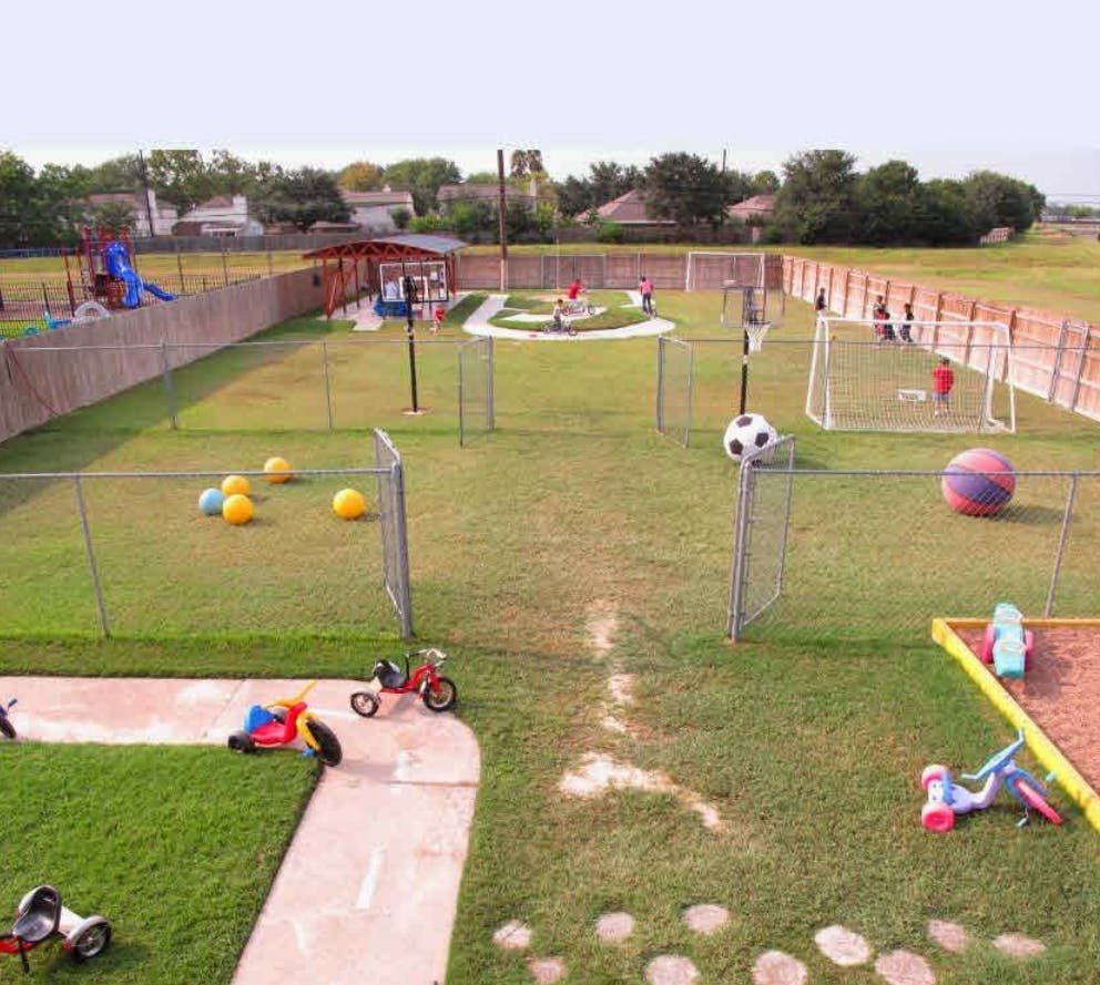 Outdoor playground with various play equipment and sports balls
