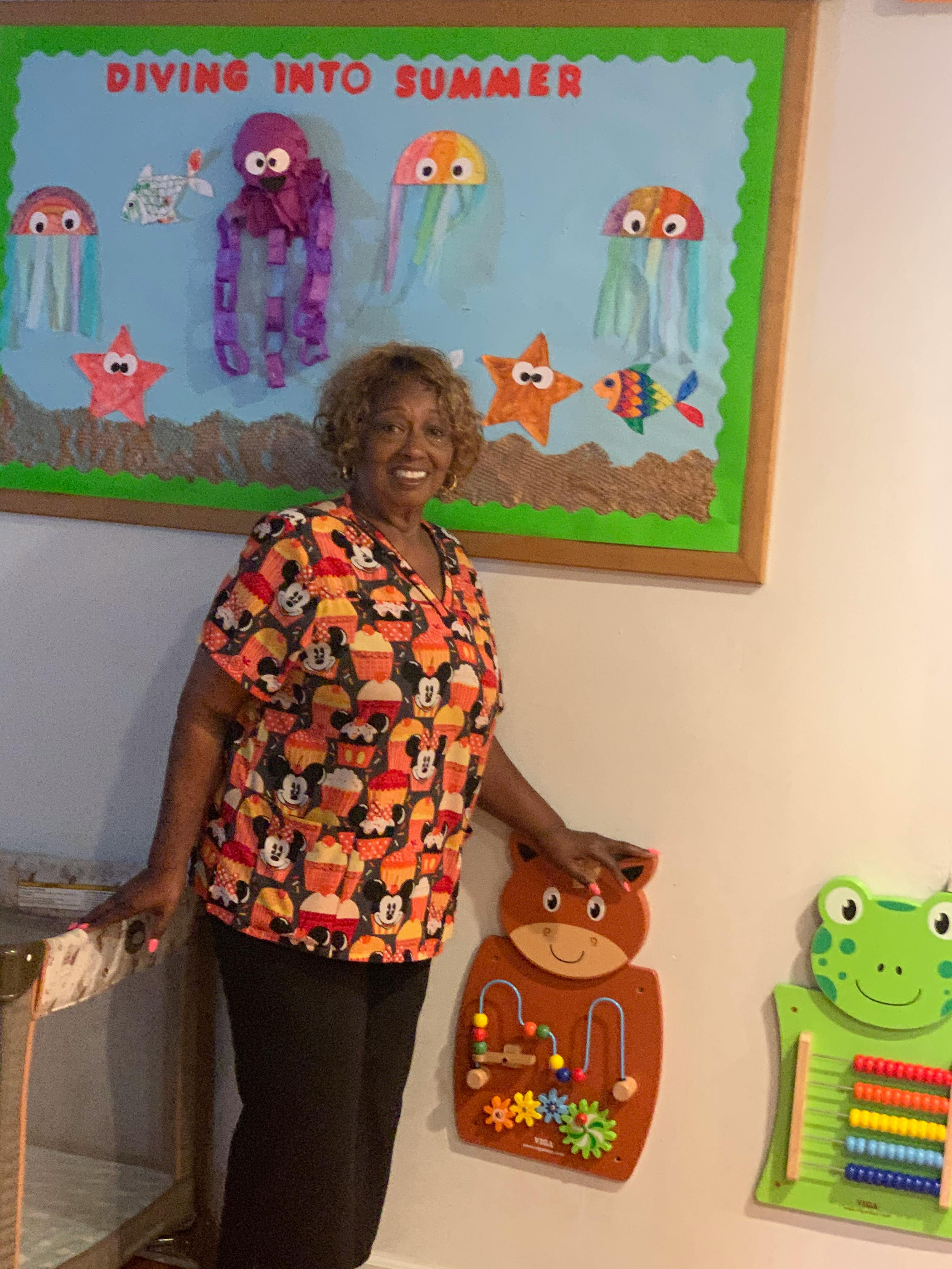 Person standing next to a bulletin board with "Diving into Summer" text