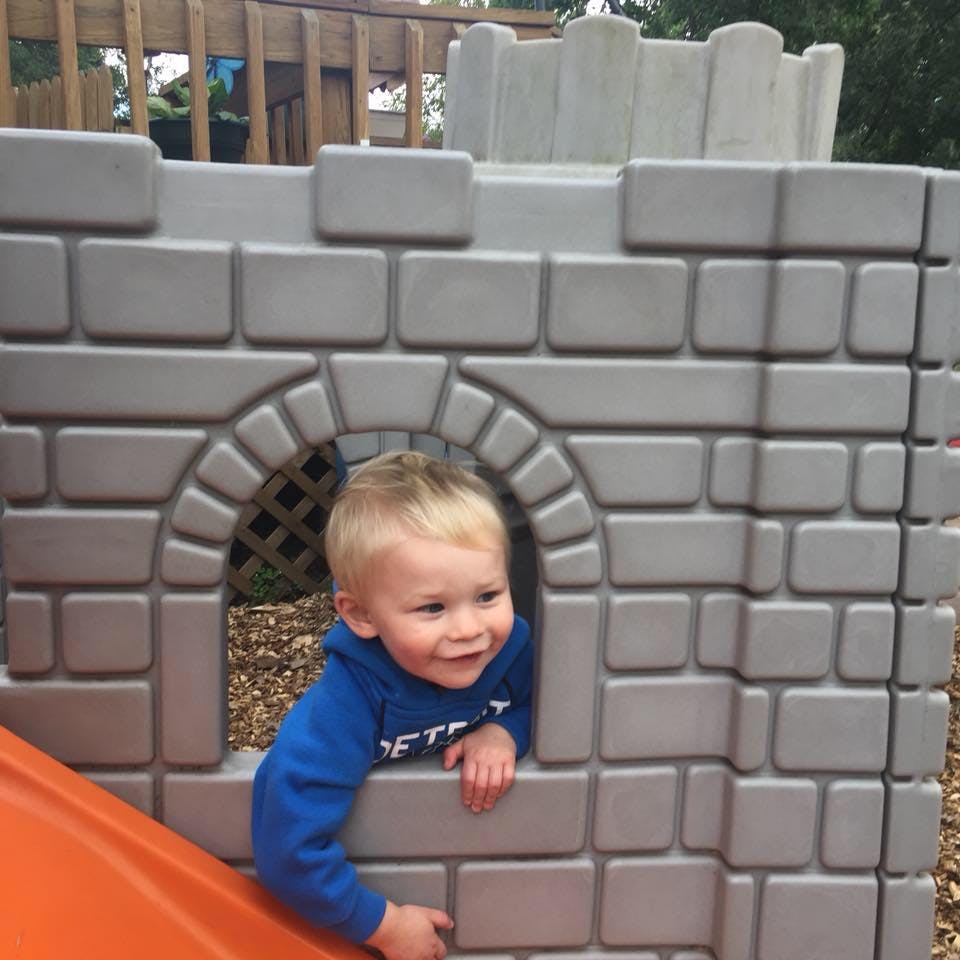 Child looking out of a toy castle window