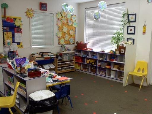Classroom with tables, chairs, shelves, and decorations