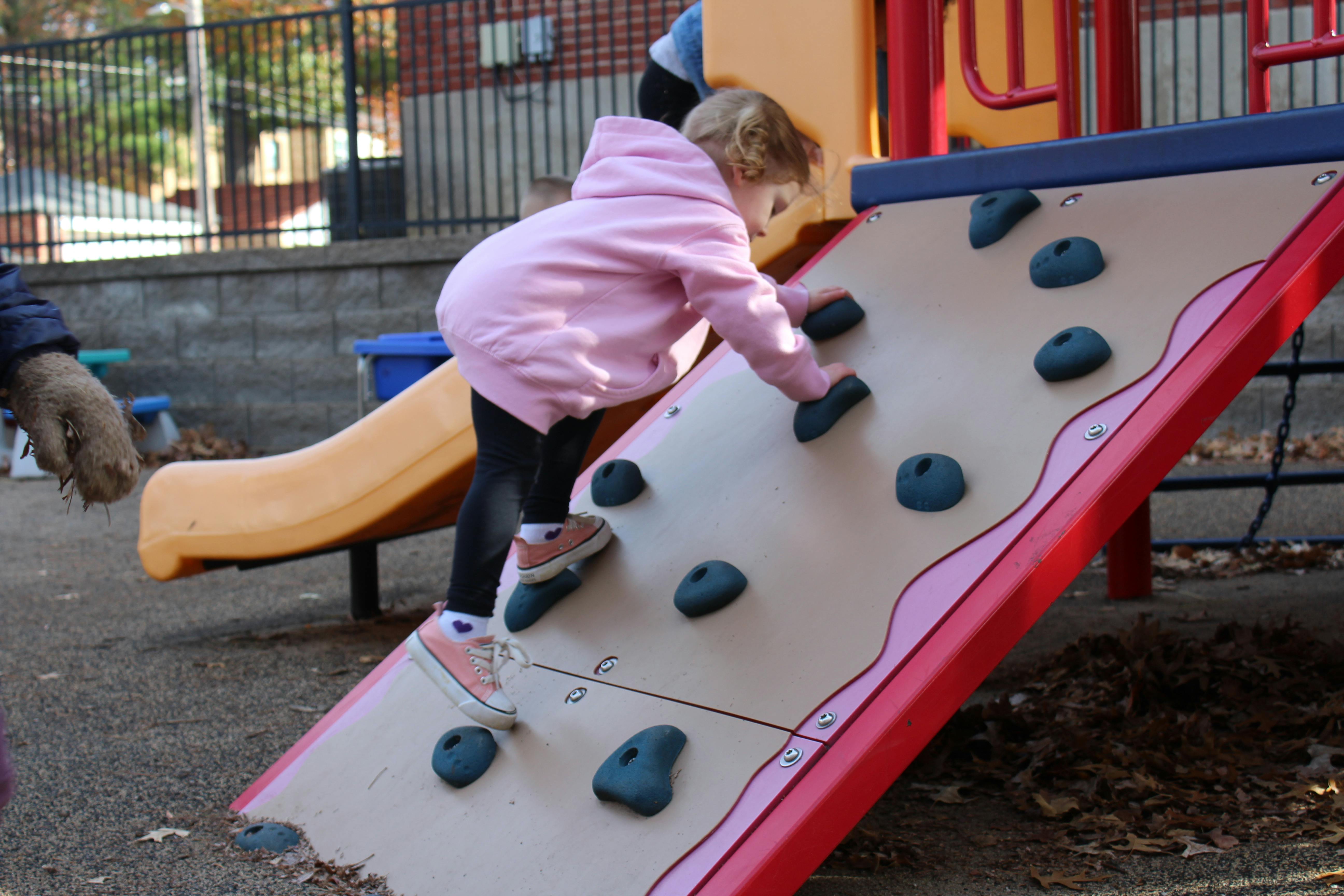Child climbing a rock wall on a playground
