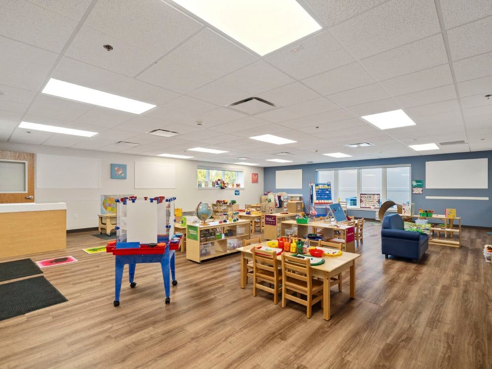 Empty colorful children's classroom with small tables and chairs