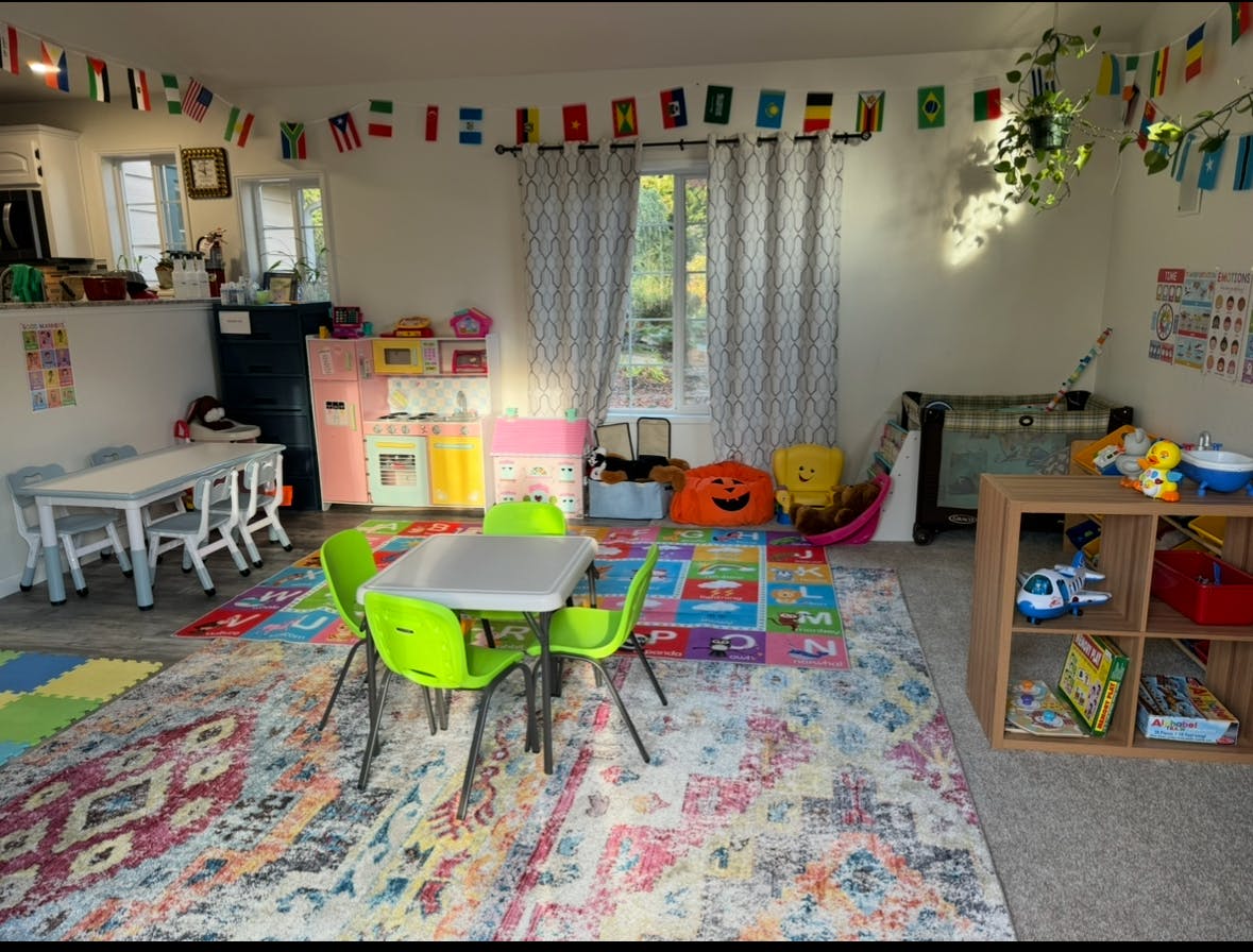 Playroom with small tables and chairs, colorful rug, and toys