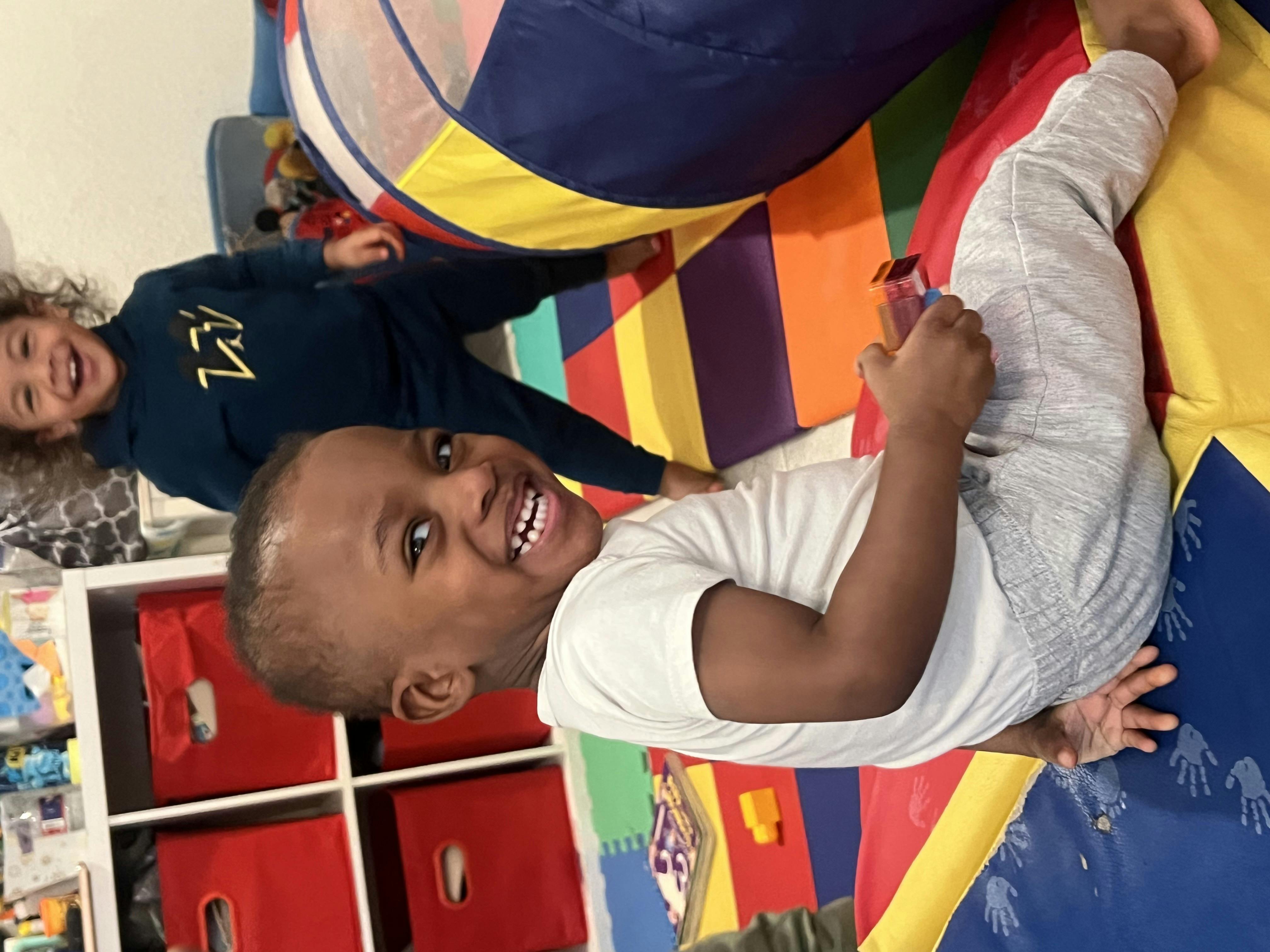 Two children playing on a colorful mat