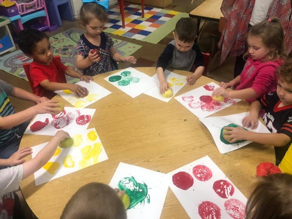 Children doing potato printing at a table
