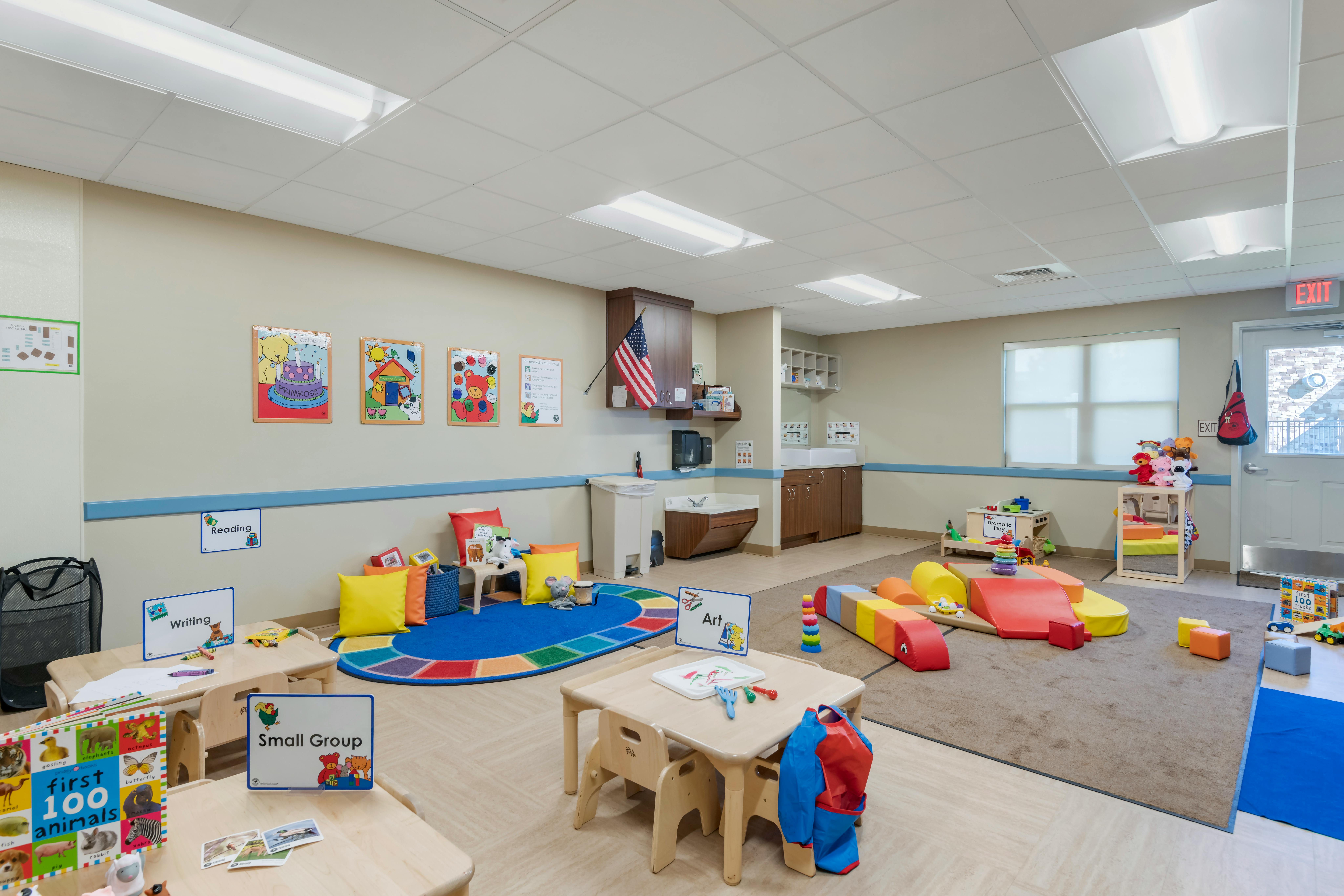 Classroom with activity areas for reading, writing, and art, play mats, and small tables