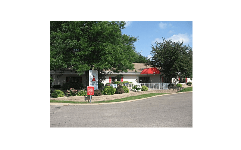 A low, long building with a red awning and a sign for "KinderCare Learning Center"