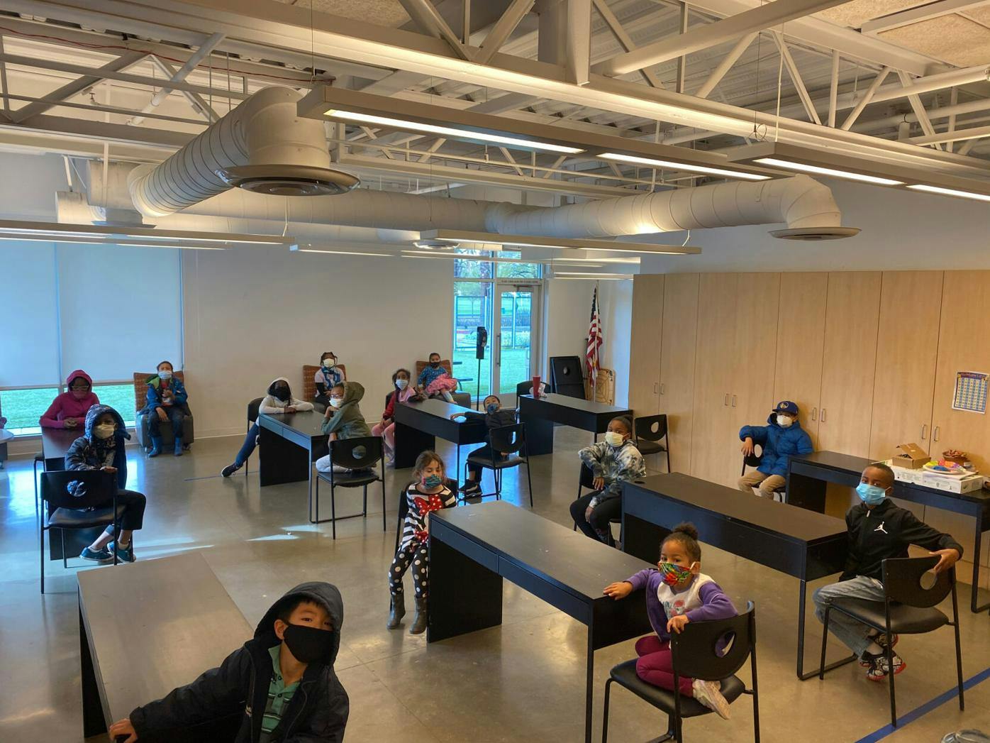 Children and teens sitting at desks in a classroom