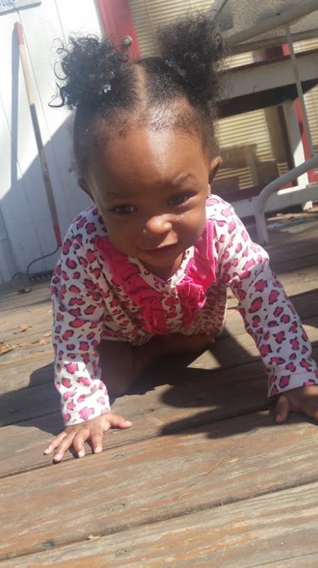 Child crawling on a wooden deck