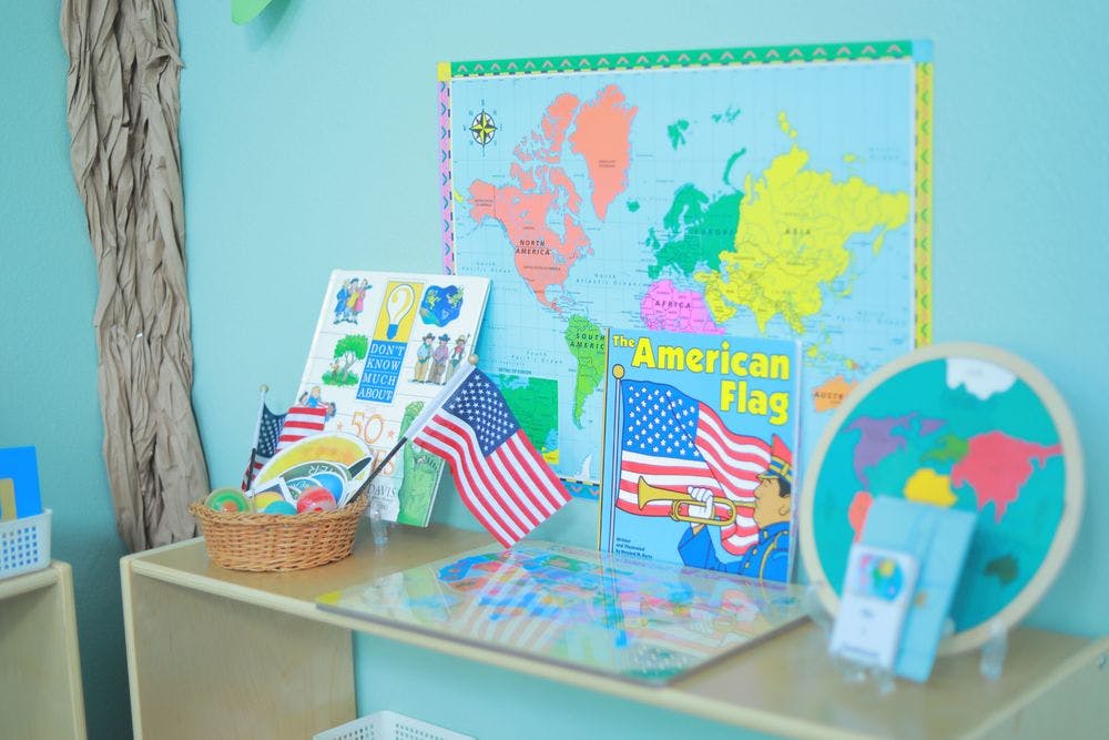 Classroom display with world map, American flags, and a book titled "American Flag"