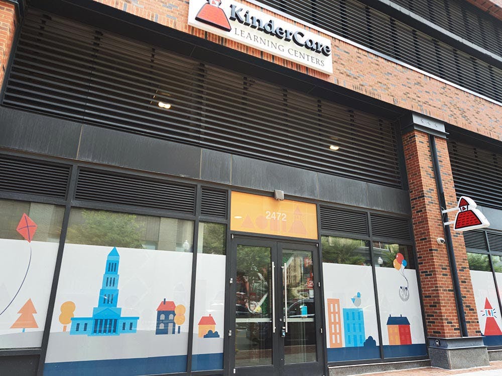 KinderCare Learning Centers sign on a brick building with illustrated window decals