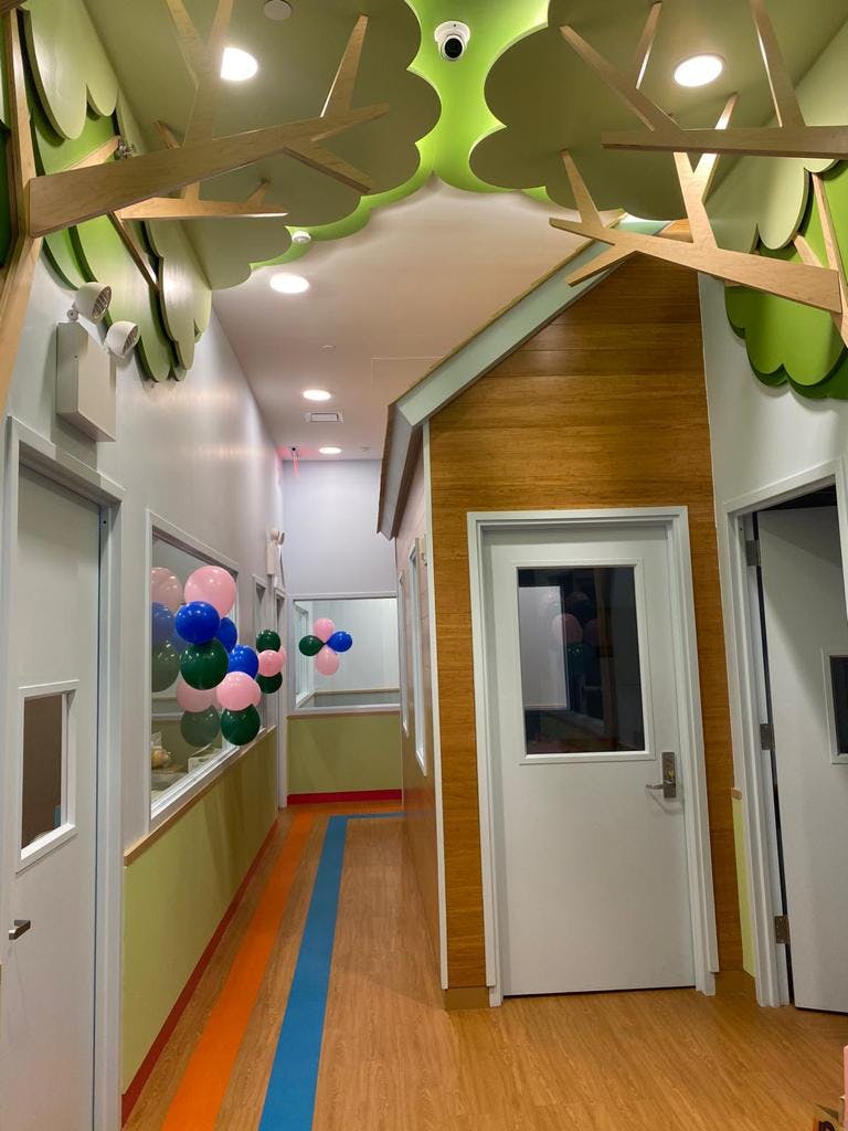 Hallway with tree-like ceiling decor and a playhouse structure