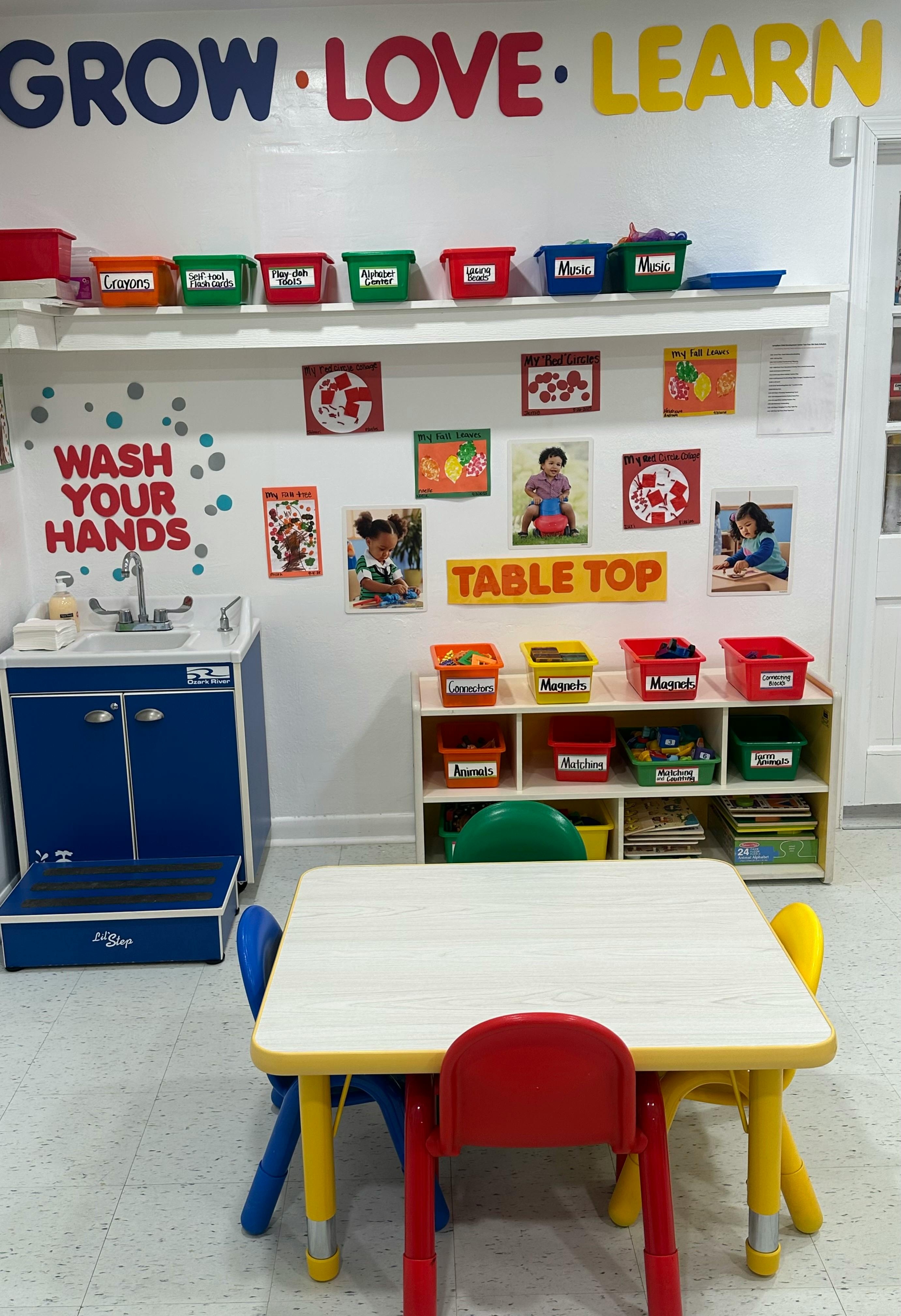 Classroom with a sink, storage shelves, and a table with chairs