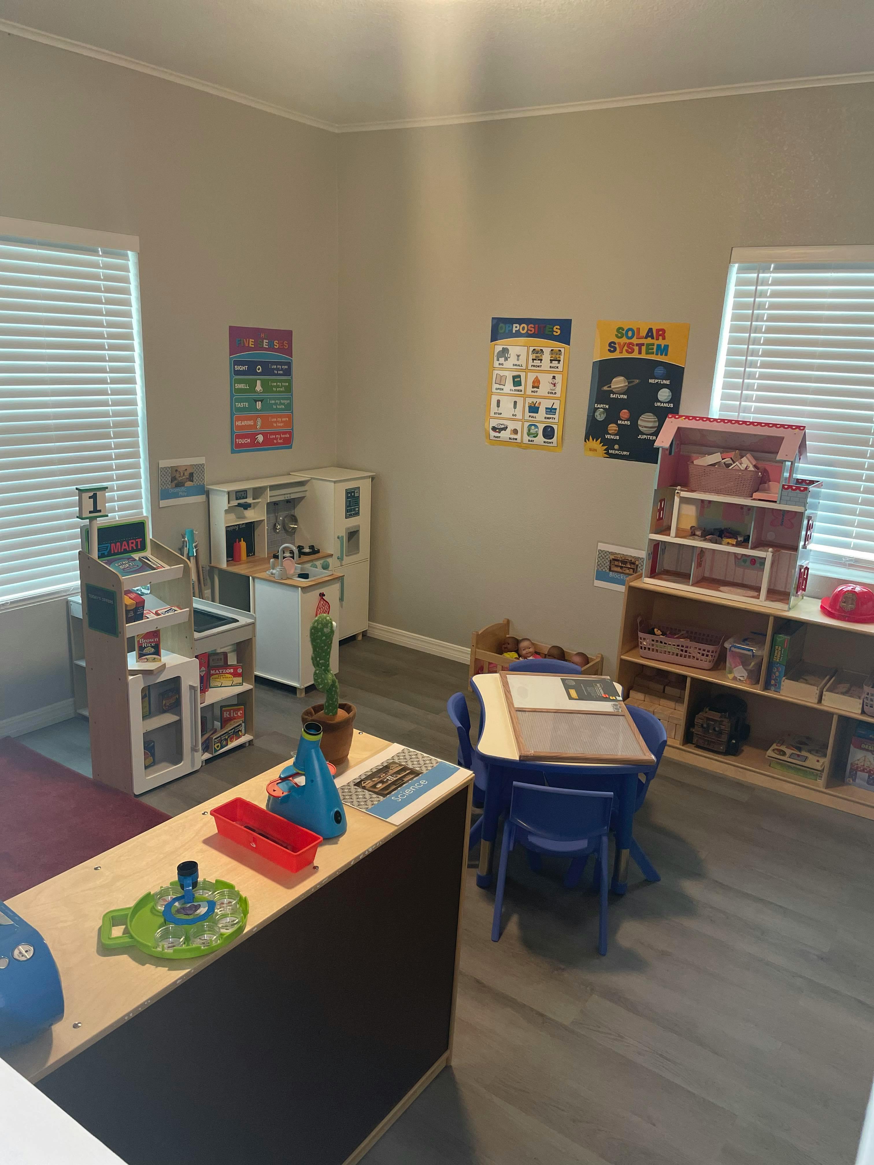 Playroom with toy kitchen, cash register, and small table with chairs