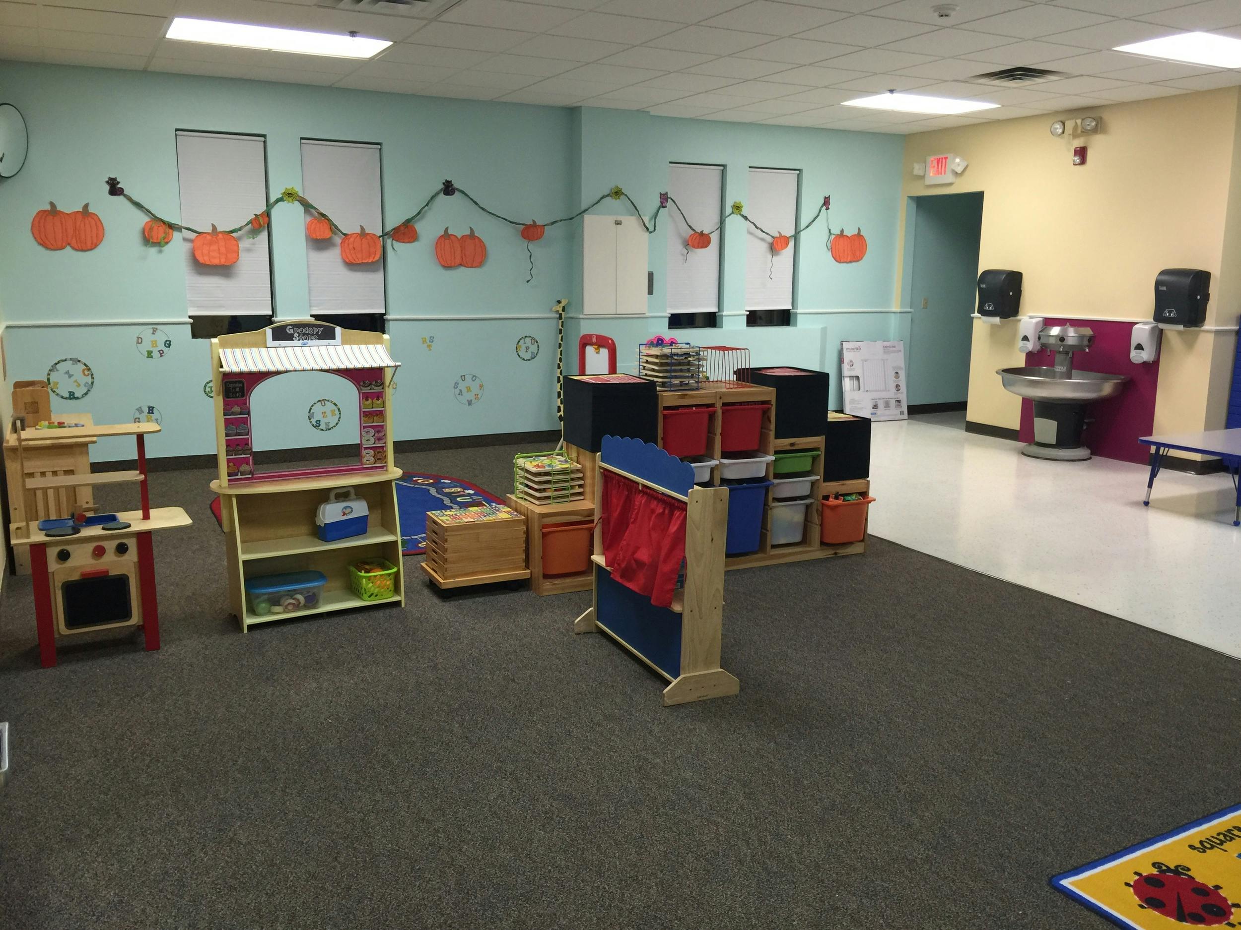 Playroom with various toys and furniture, pumpkin decorations on a string decoration