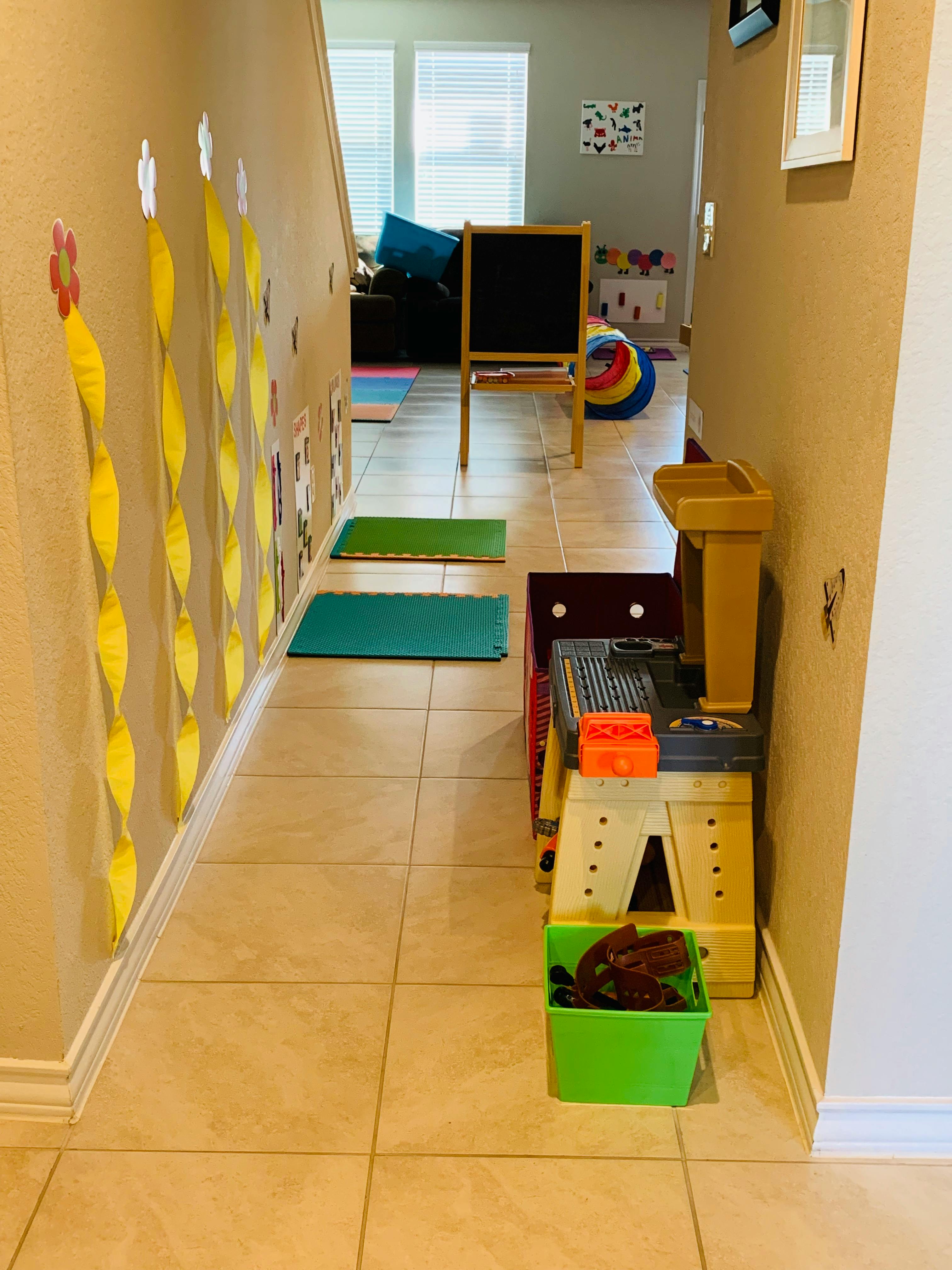 Hallway with play mats on the floor and a child's workbench