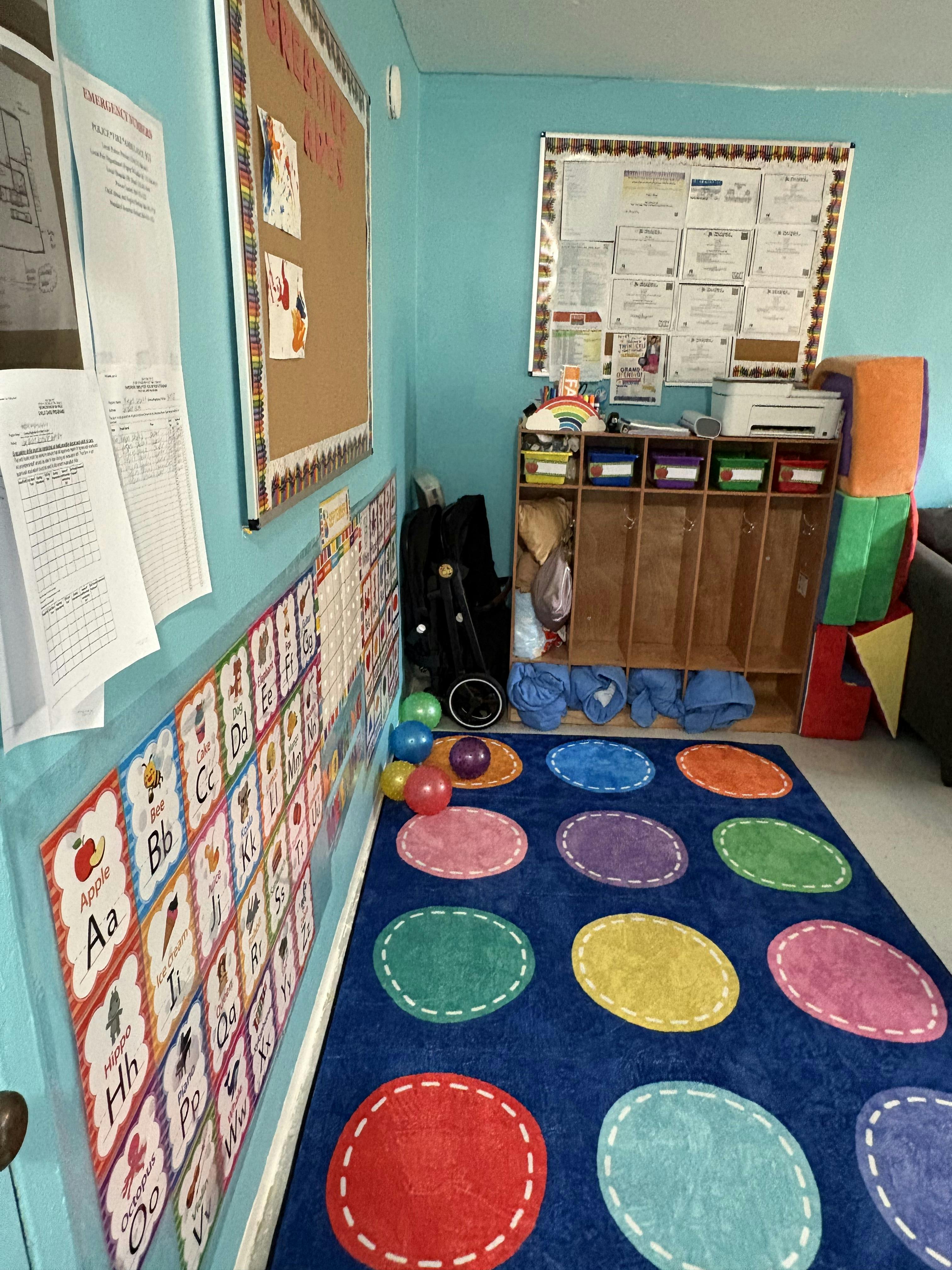 Classroom interior with alphabet wall charts and a colorful dot pattern rug