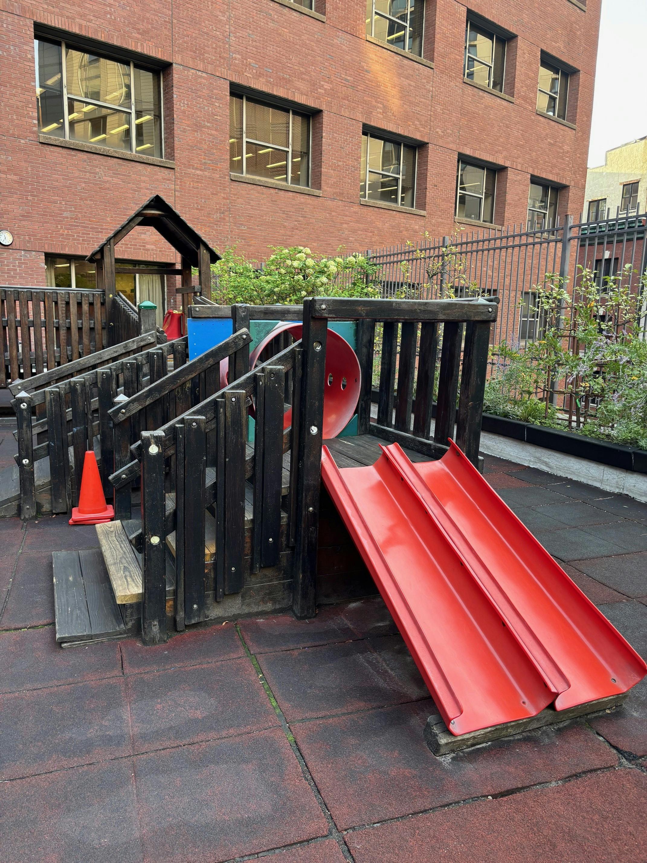 Playground with red slides and wooden structures