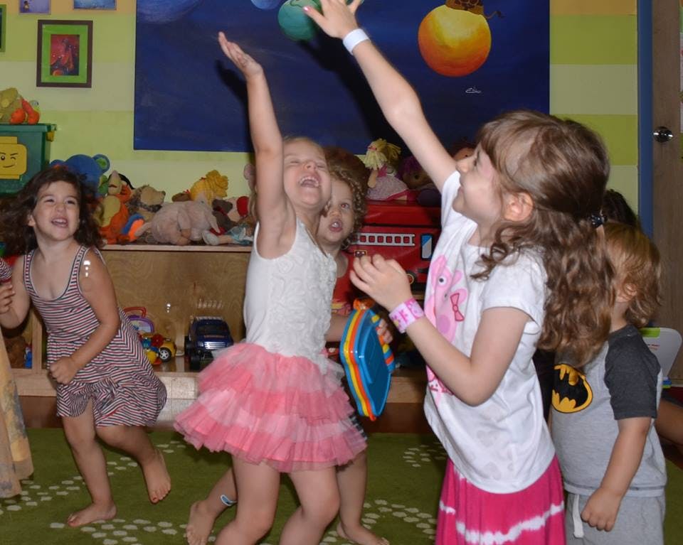 Children playing with a ball indoors