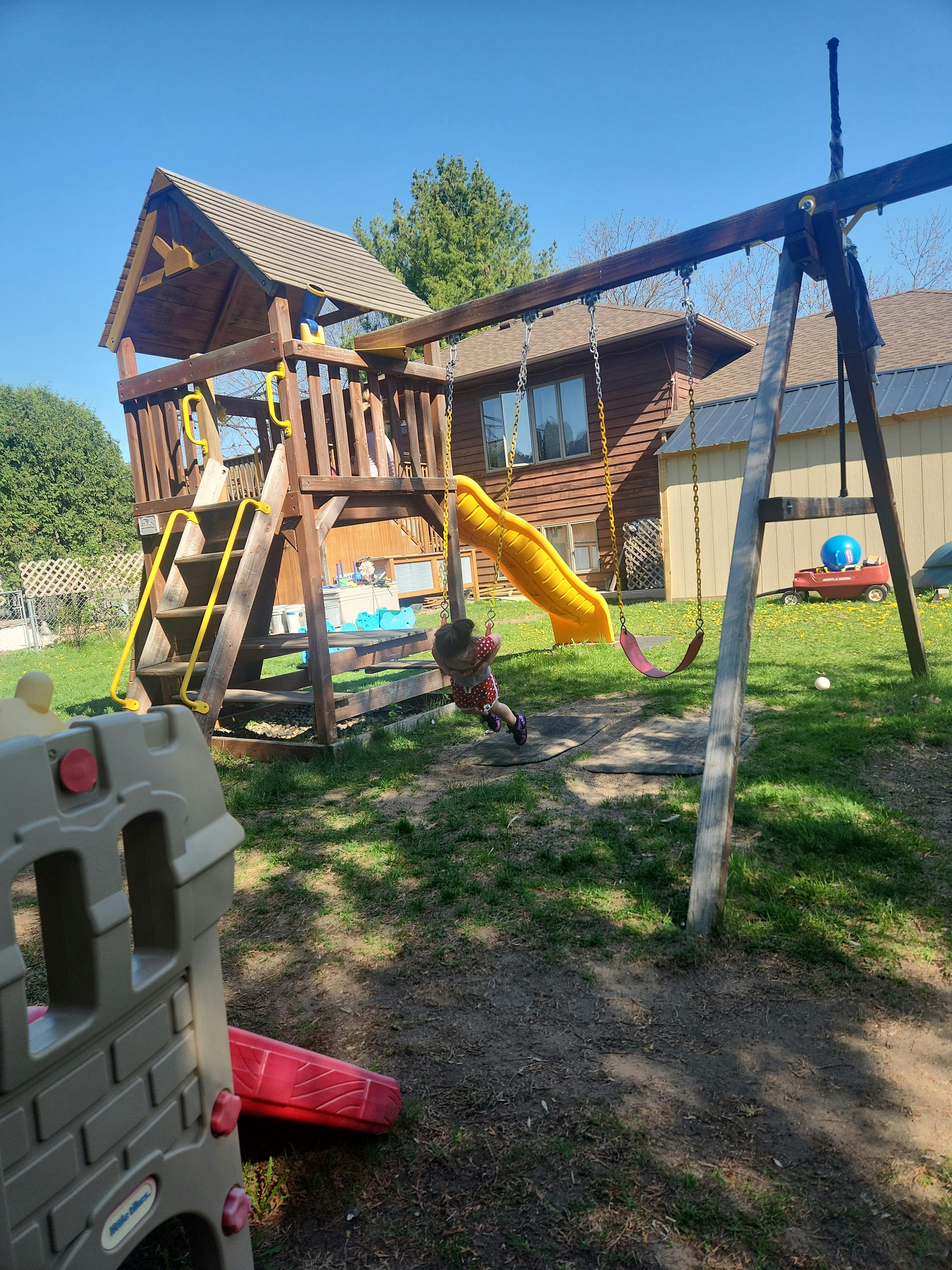 child on a swing set in a backyard playground