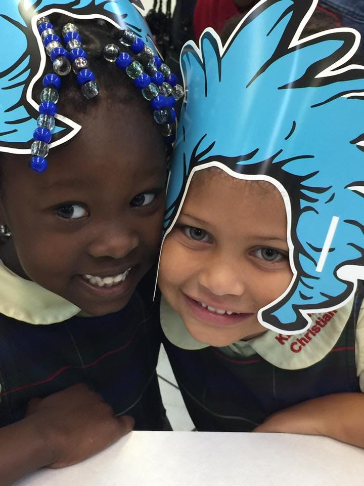 Two children wearing blue paper crowns