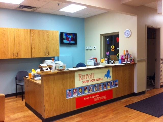 Reception desk with an "Enroll Now For Fall!" sign