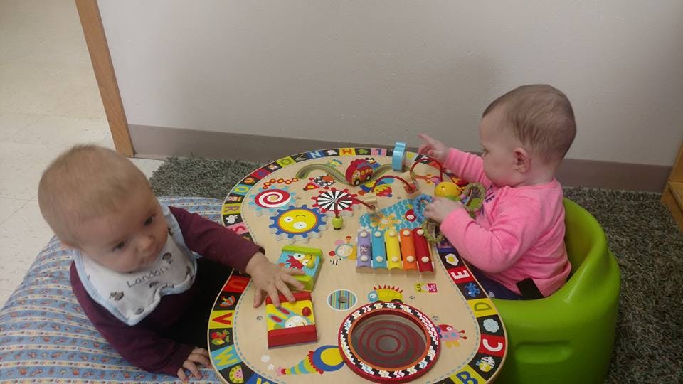 Two children playing with an activity table