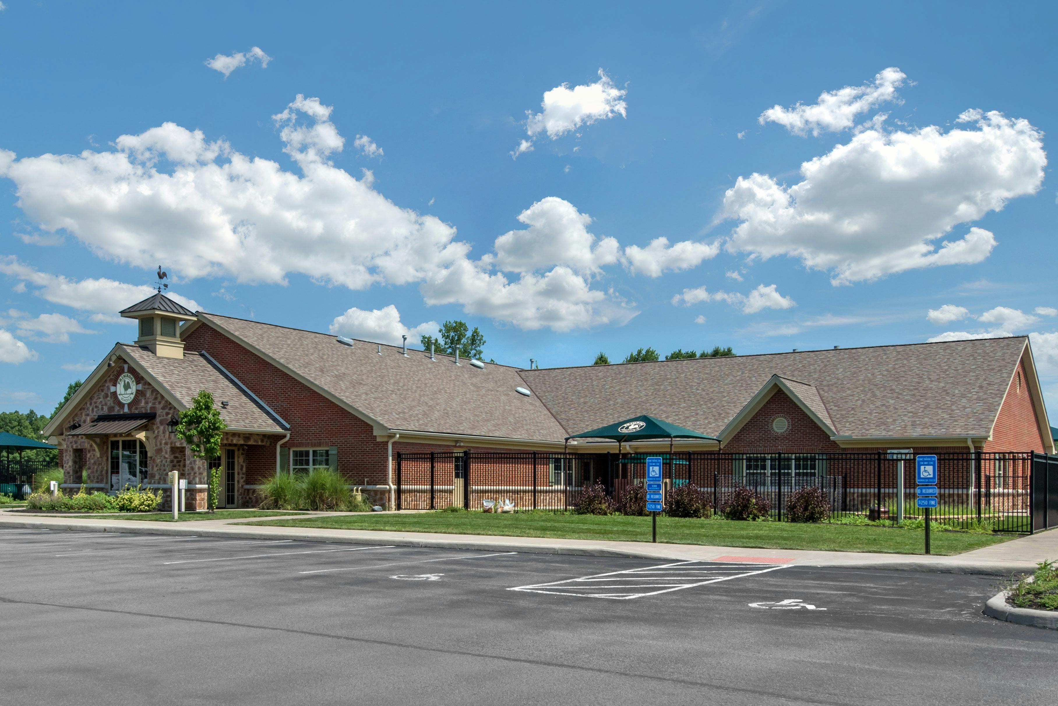 Single-story brick building with a stone entrance and weathervane