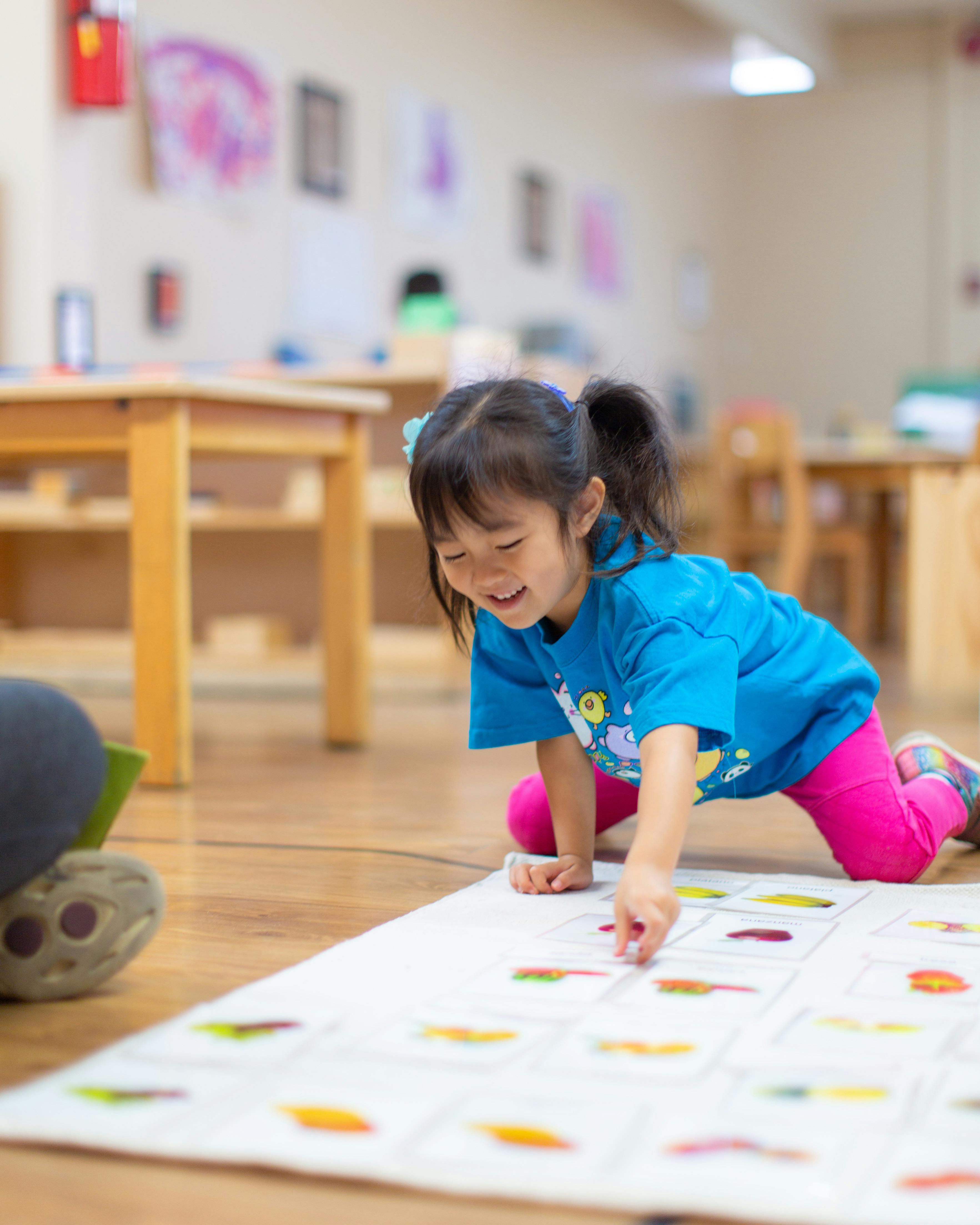 Child on floor playing with a learning mat