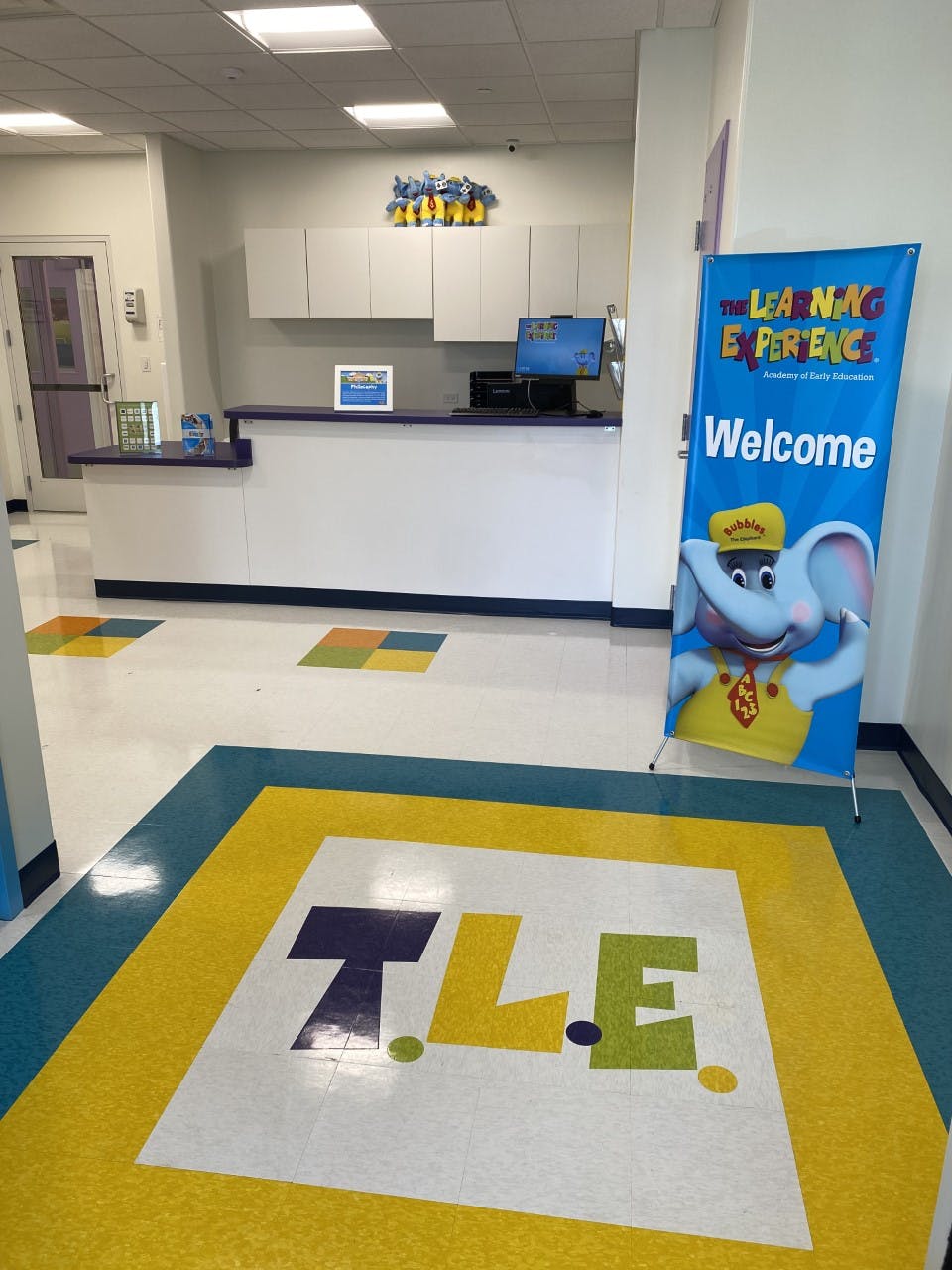 Reception desk with a welcome banner and floor logo