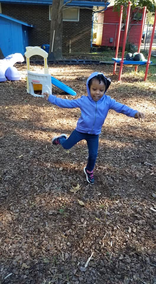 Child balancing on one leg outdoors