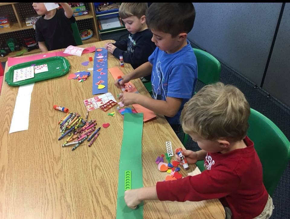 Three children doing crafts at a table